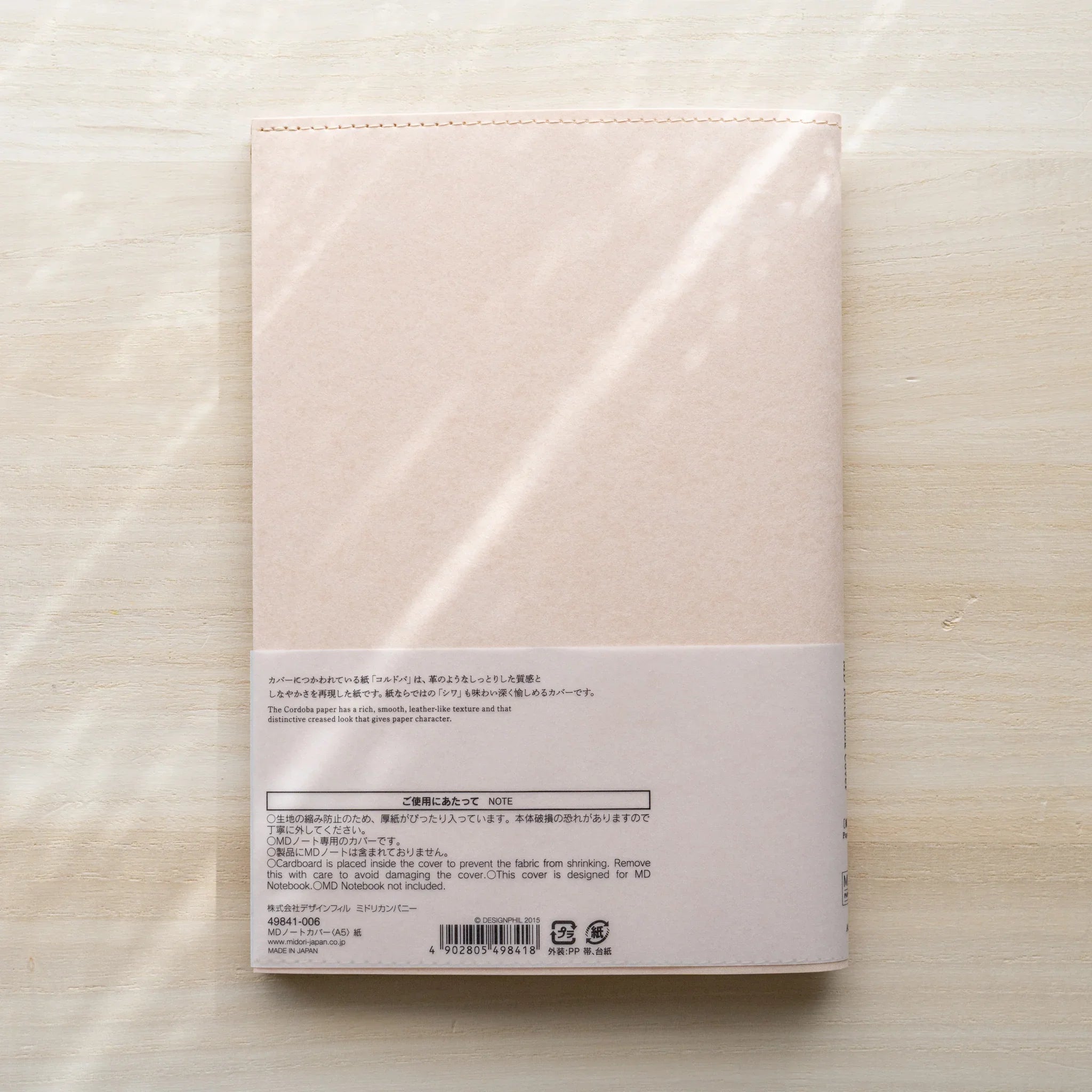 Midori MD Notebook Paper Cover back view with pale pink paper, belly band showing care instructions, product code and barcode
