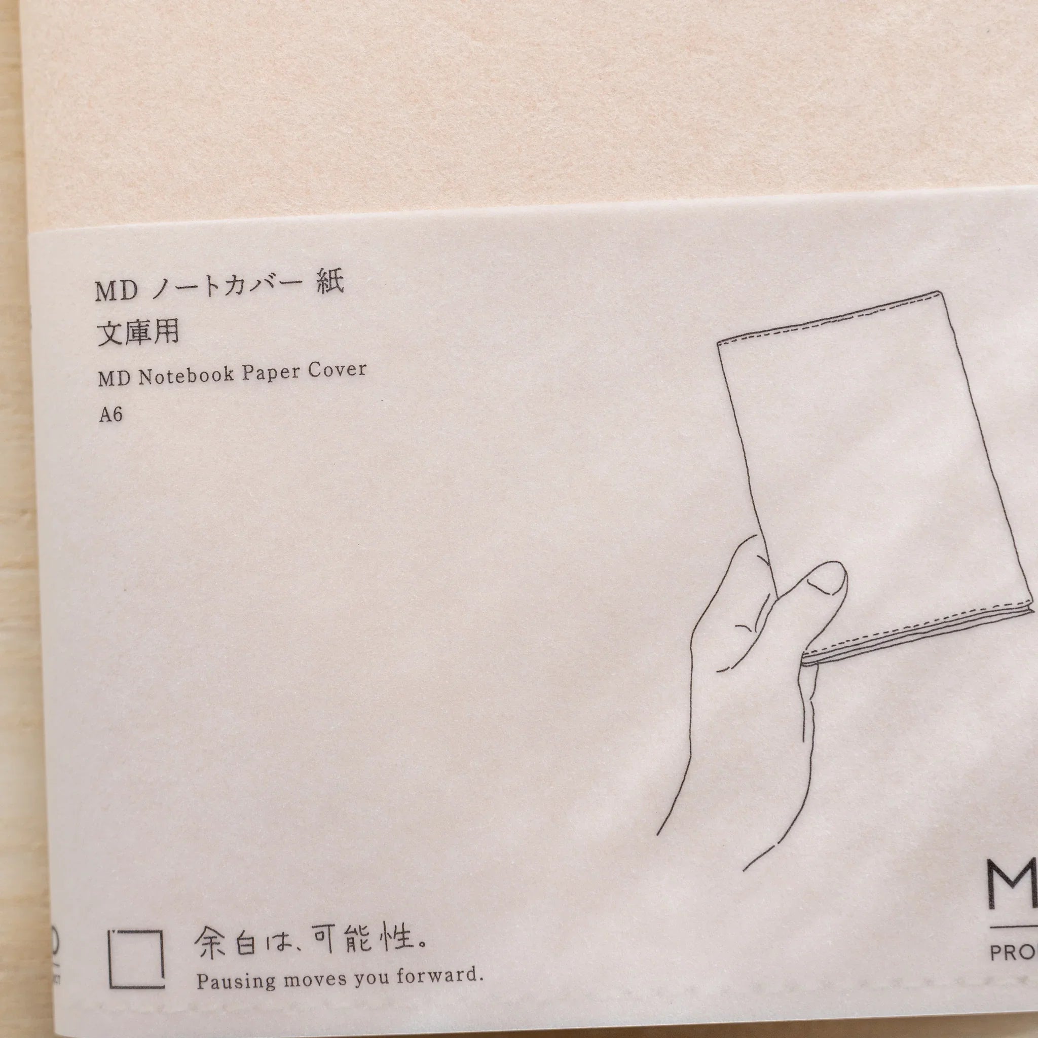 MD Notebook Paper Cover A6 belly band with Japanese and English title, hand-holding-notebook illustration and MD logo