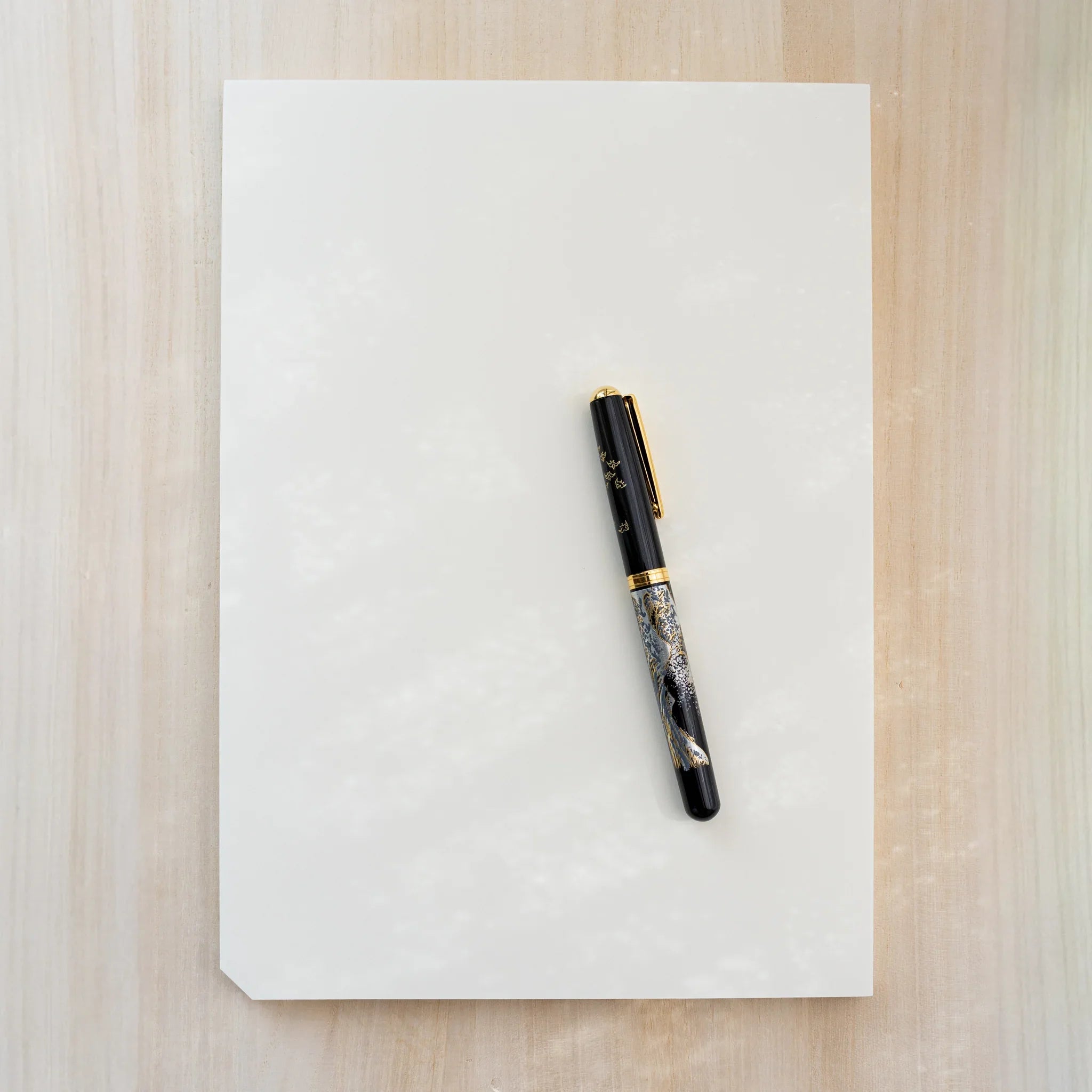 Midori MD Paper Pad A4, plain cream top sheet with a black and gold Japanese-pattern fountain pen on top