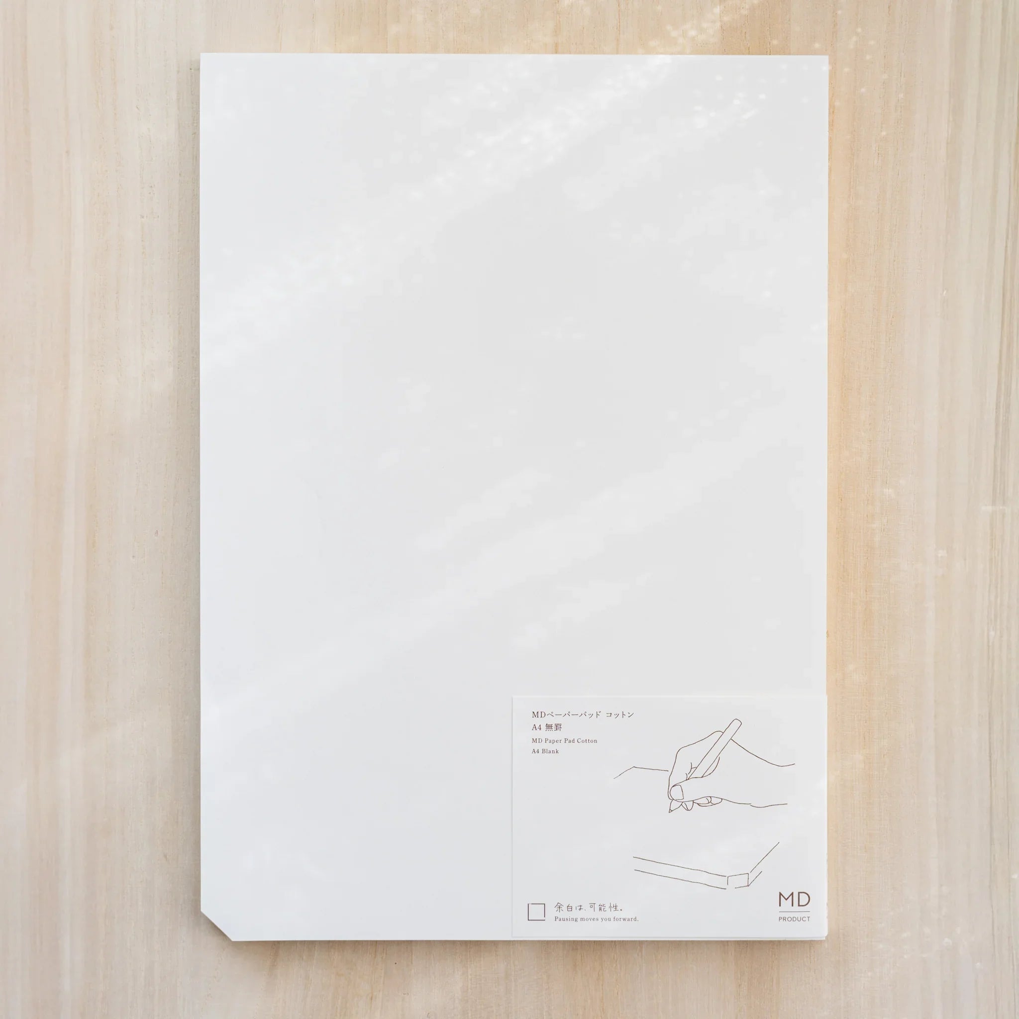 Midori MD Paper Pad Cotton A4, white top sheet with paper belly band reading MD Paper Pad Cotton A4 Blank and hand drawing