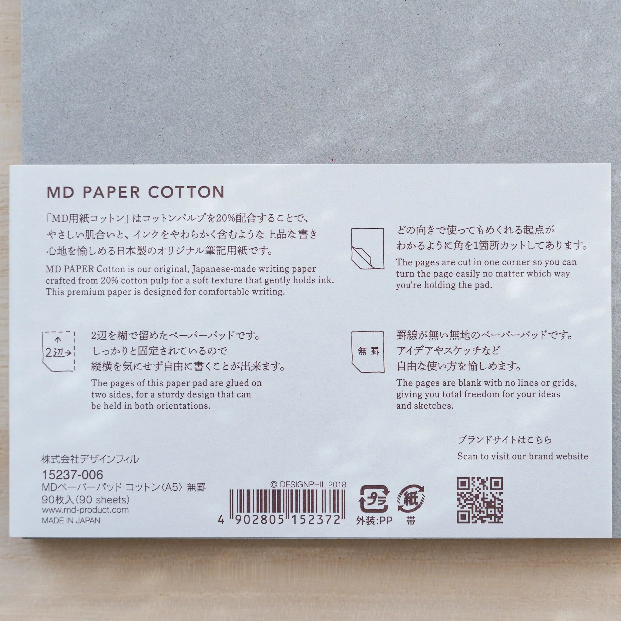 Close-up of Midori MD Paper Pad Cotton A5 belly band text on 20% cotton paper, 90 sheets, blank, cut corner