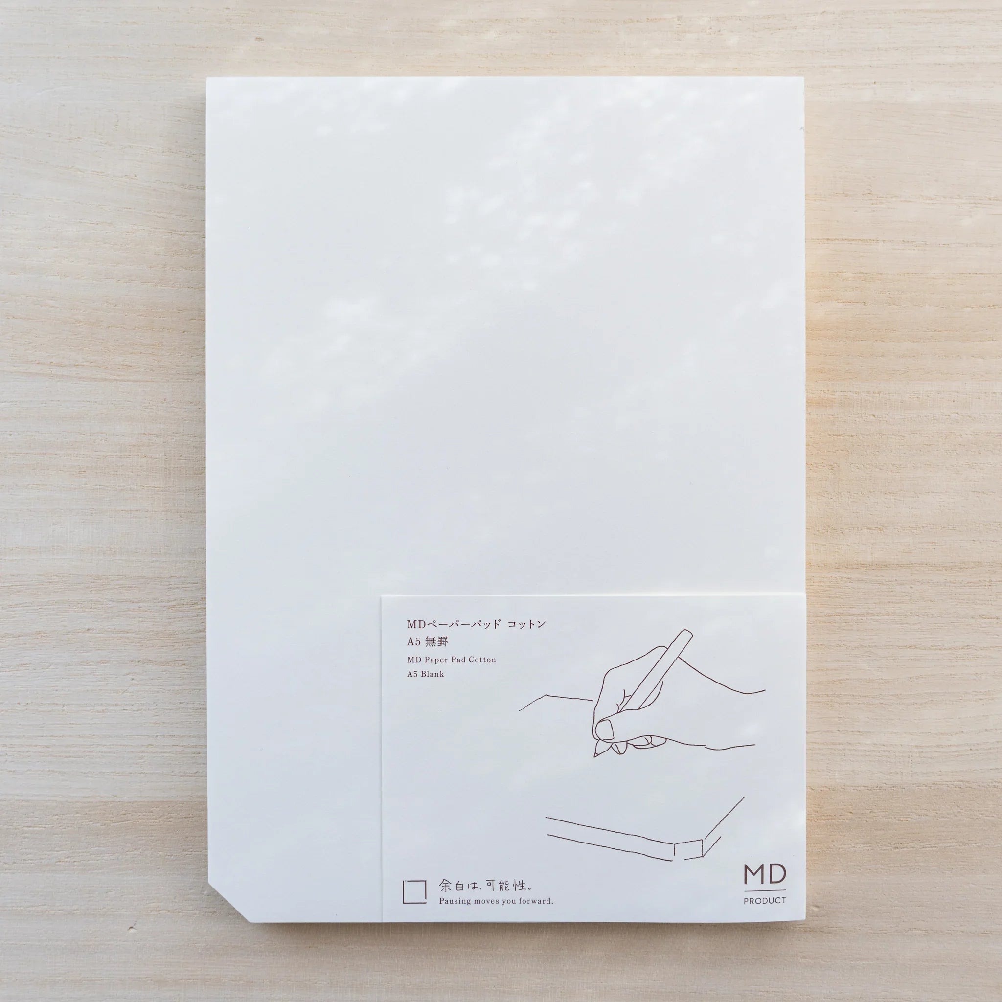 Midori MD Paper Pad Cotton A5, white top sheet with paper belly band reading MD Paper Pad Cotton A5 Blank and hand drawing