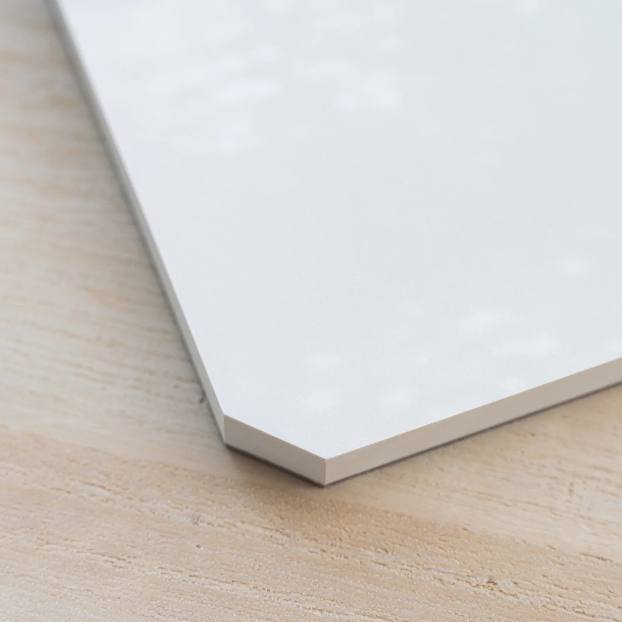 Close-up of the angled cut corner of a Midori MD Paper Pad Cotton A5 with page block on a gray backing board