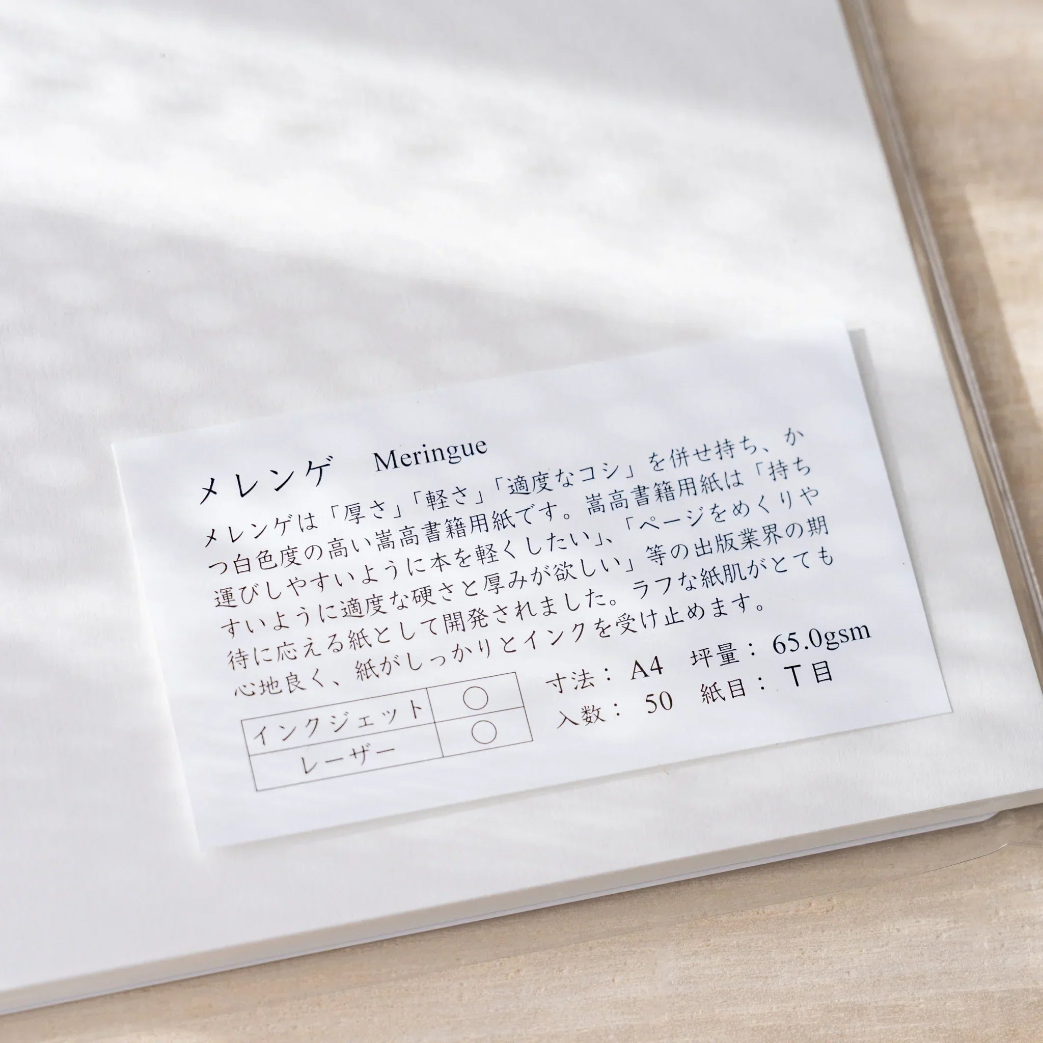 Close-up of Yamamoto Paper Meringue A4 loose leaf paper label showing 65gsm T-grain 50-sheet specs.