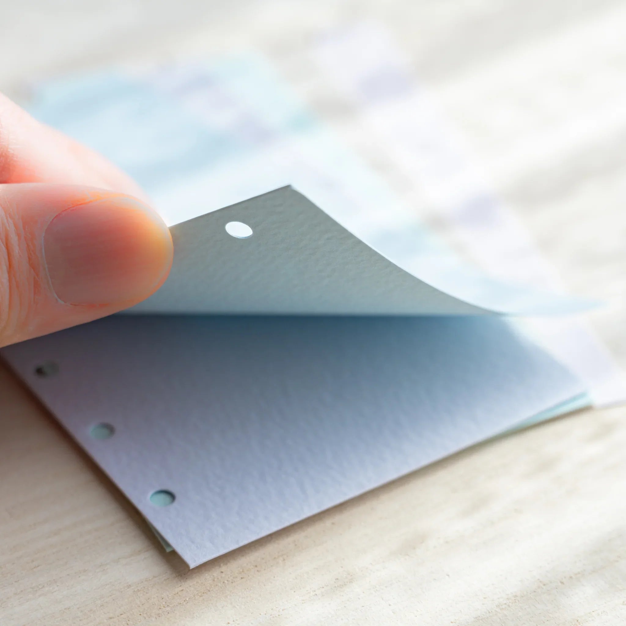 Japanese Stationery hand lifting pastel index divider sheet for mini 6 planner, highlighting thickness and six-hole edge.