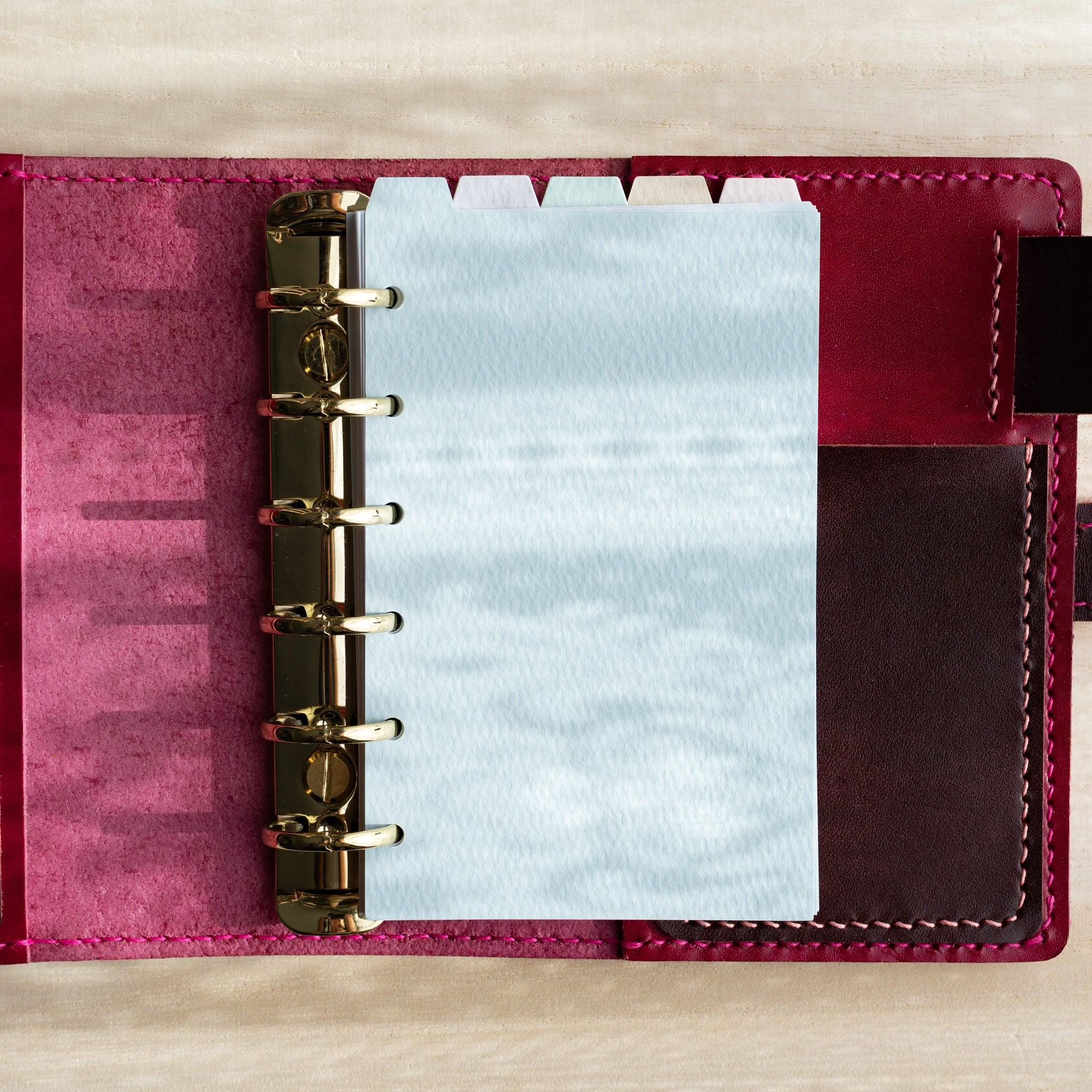 Japanese Stationery mini 6 planner open with pastel blue index divider inserted in red leather binder, showing top tab design.