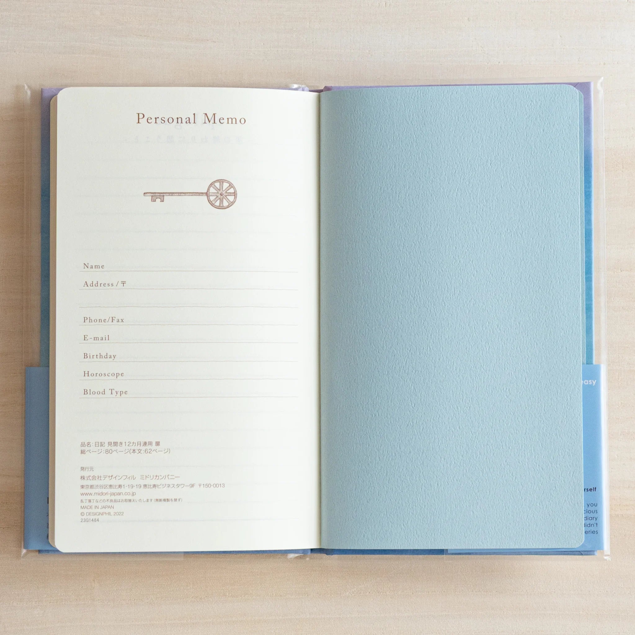 Open Midori Japanese journal showing personal memo page and a textured blank blue page on the right.