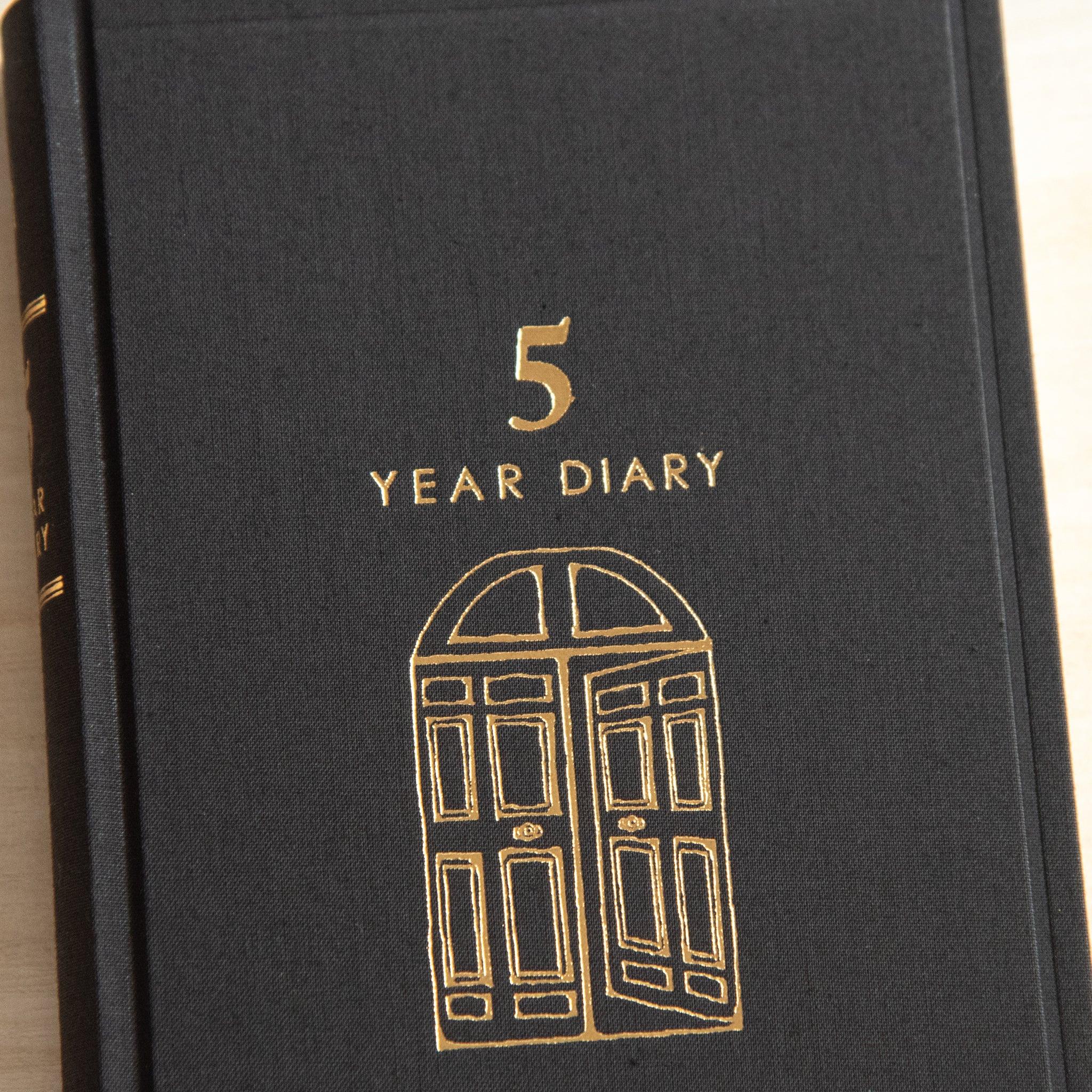 Midori 5 Year Journal Gate Design Japanese Journal close up of gold door illustration and title on black cover.