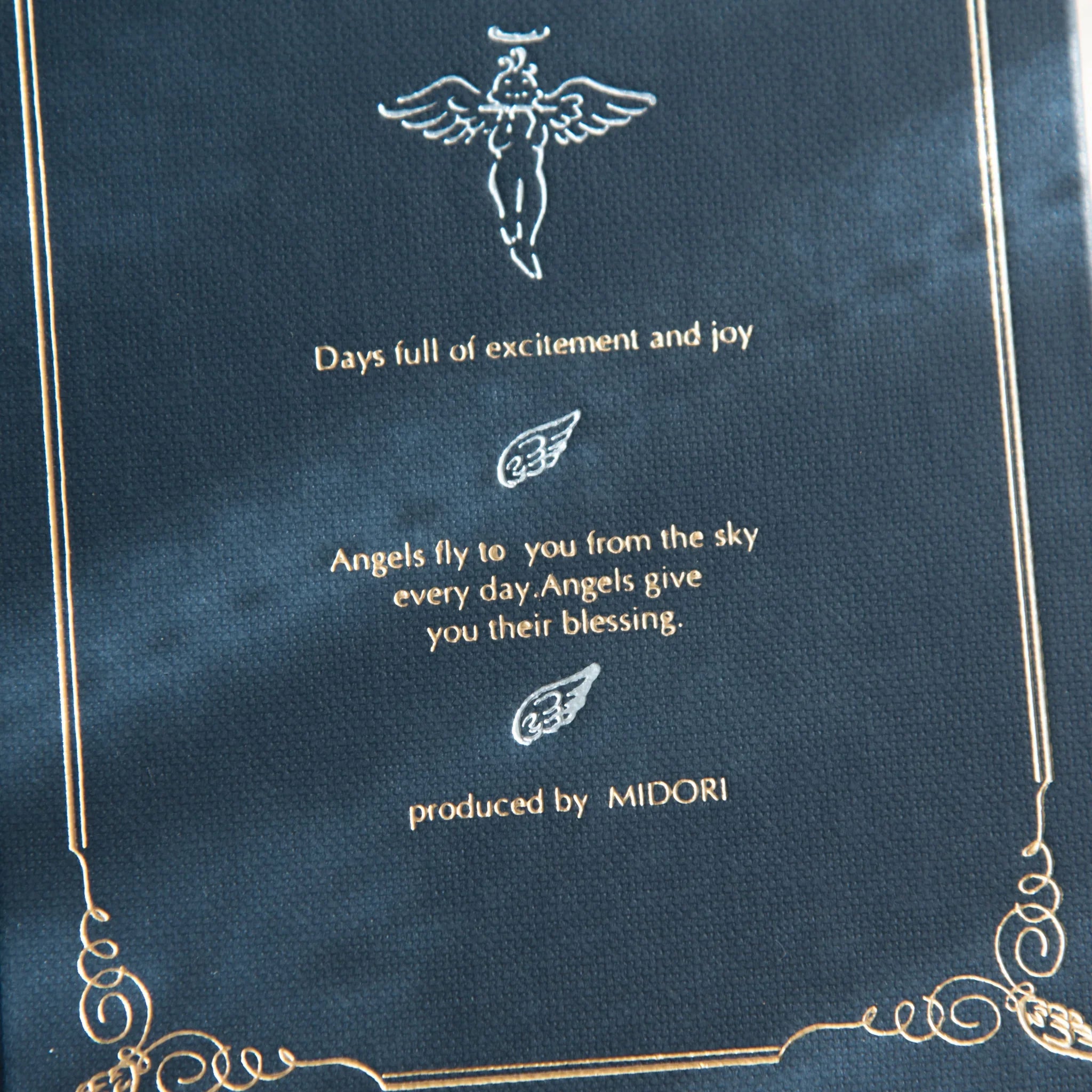 Close-up of Midori Angel Motif Journal cover with gold angel illustration and inspirational quote on navy blue background