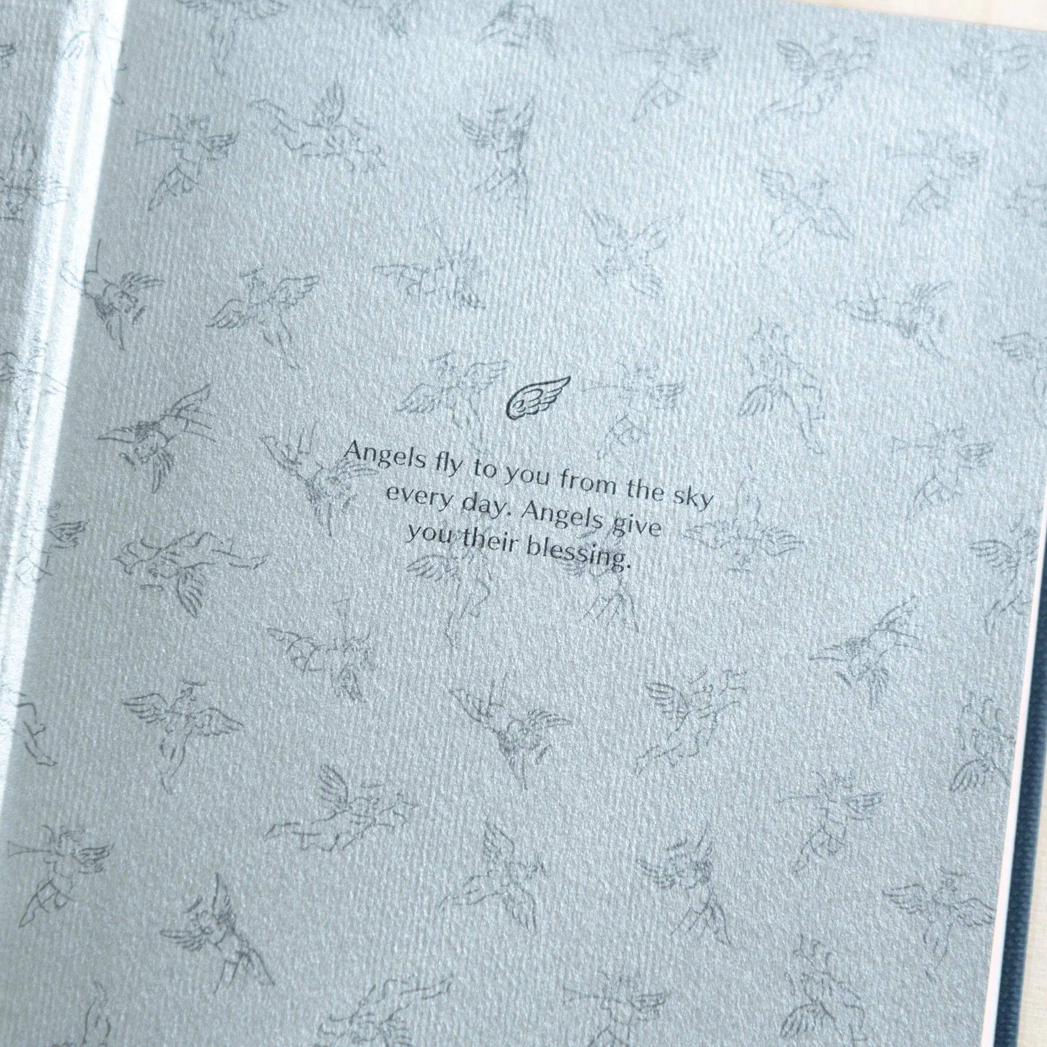 Close-up of Midori Angel Motif Journal inner page with delicate angel motif pattern and inspirational quote about angels