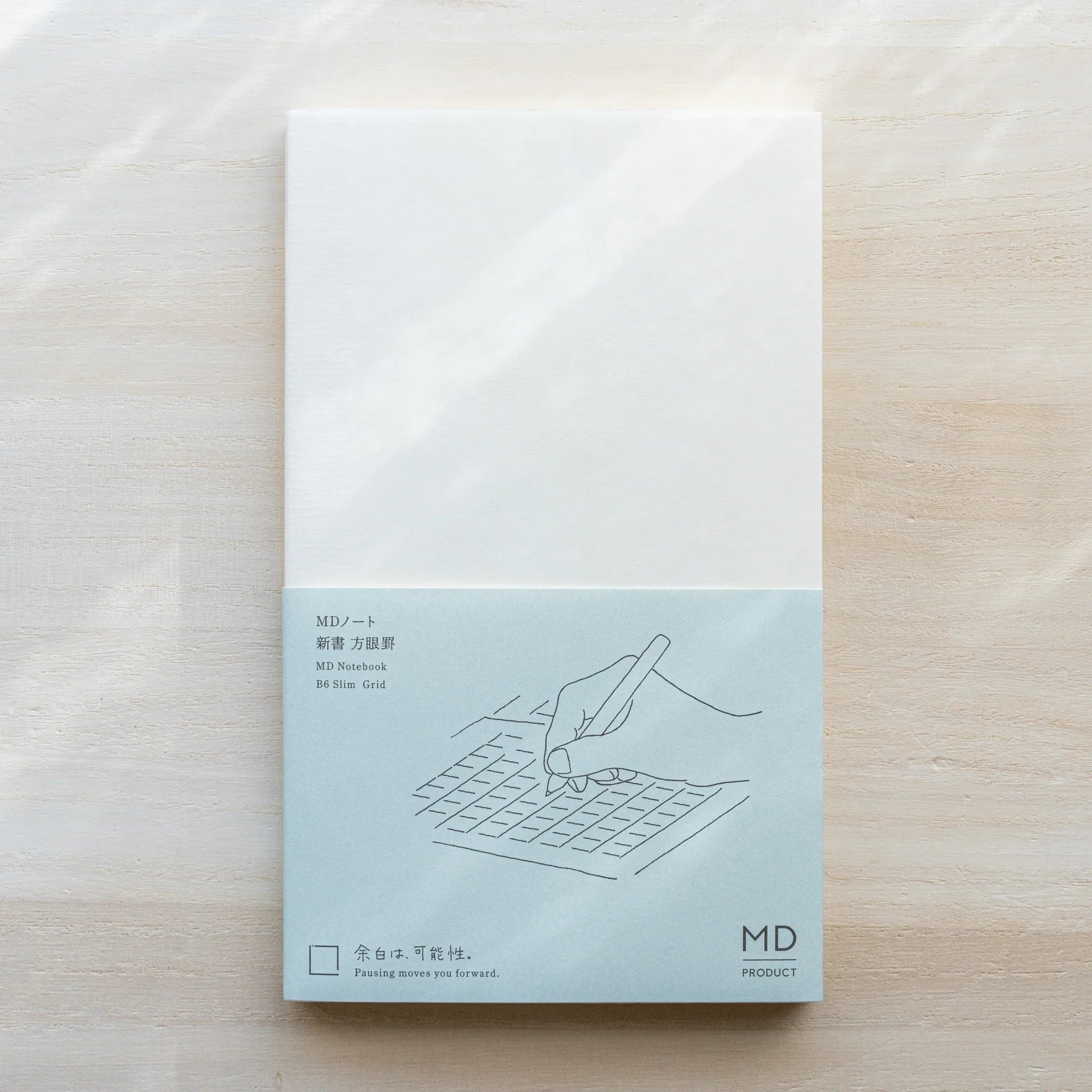 Midori MD Notebook B6 Slim Grid cover, white upper half, teal lower half with grid writing illustration, MD PRODUCT logo