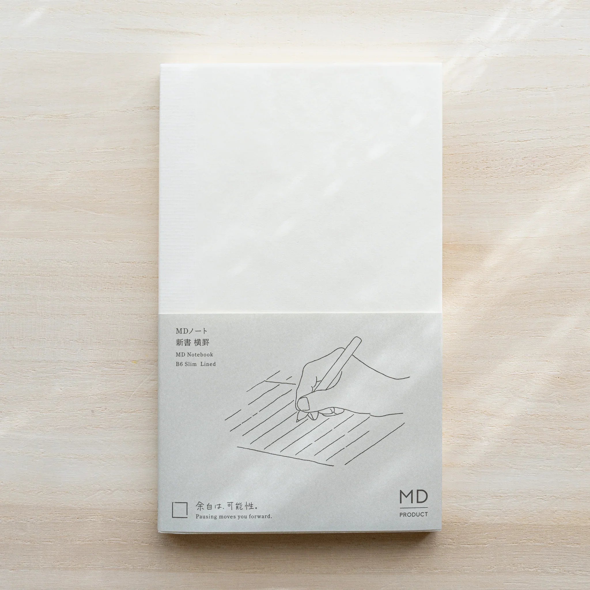 Midori MD Notebook B6 Slim Lined cover, white upper half, gray lower half with hand on lines illustration, MD PRODUCT logo