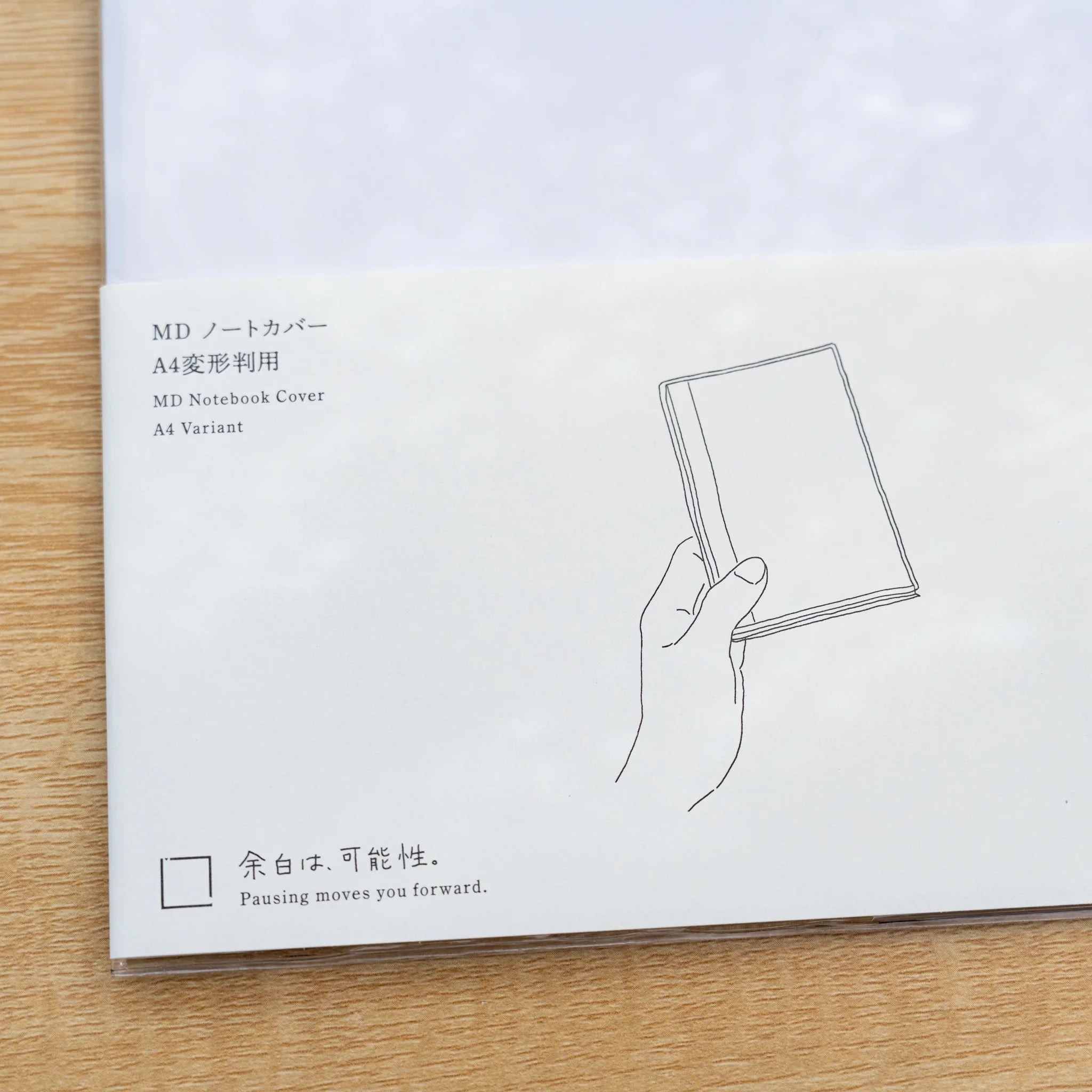 Insert card for Midori MD Notebook Cover A4 Variant with line drawing of a hand holding a covered notebook