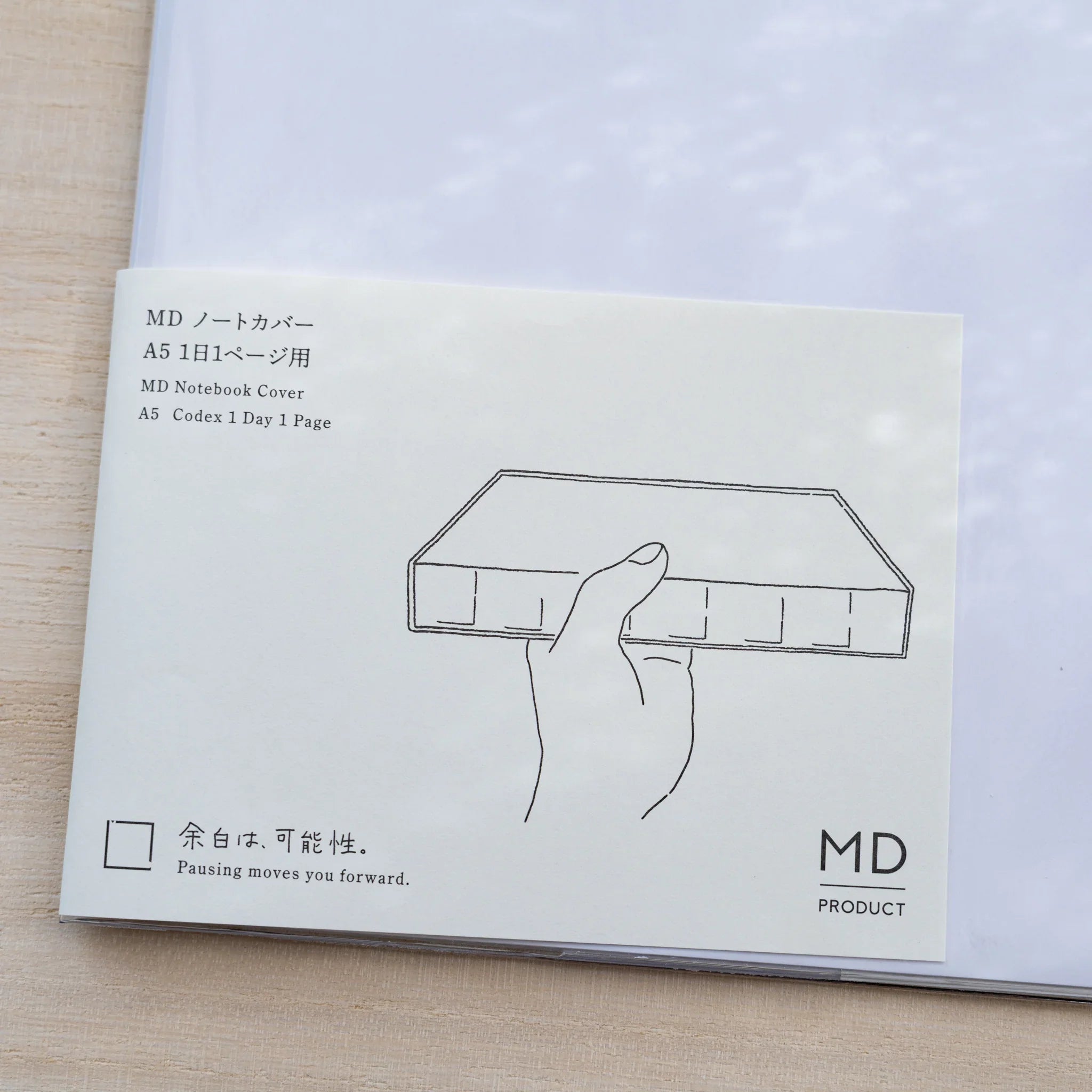 Insert card for Midori MD Notebook Cover A5 Codex 1 Day 1 Page with hand holding a thick notebook