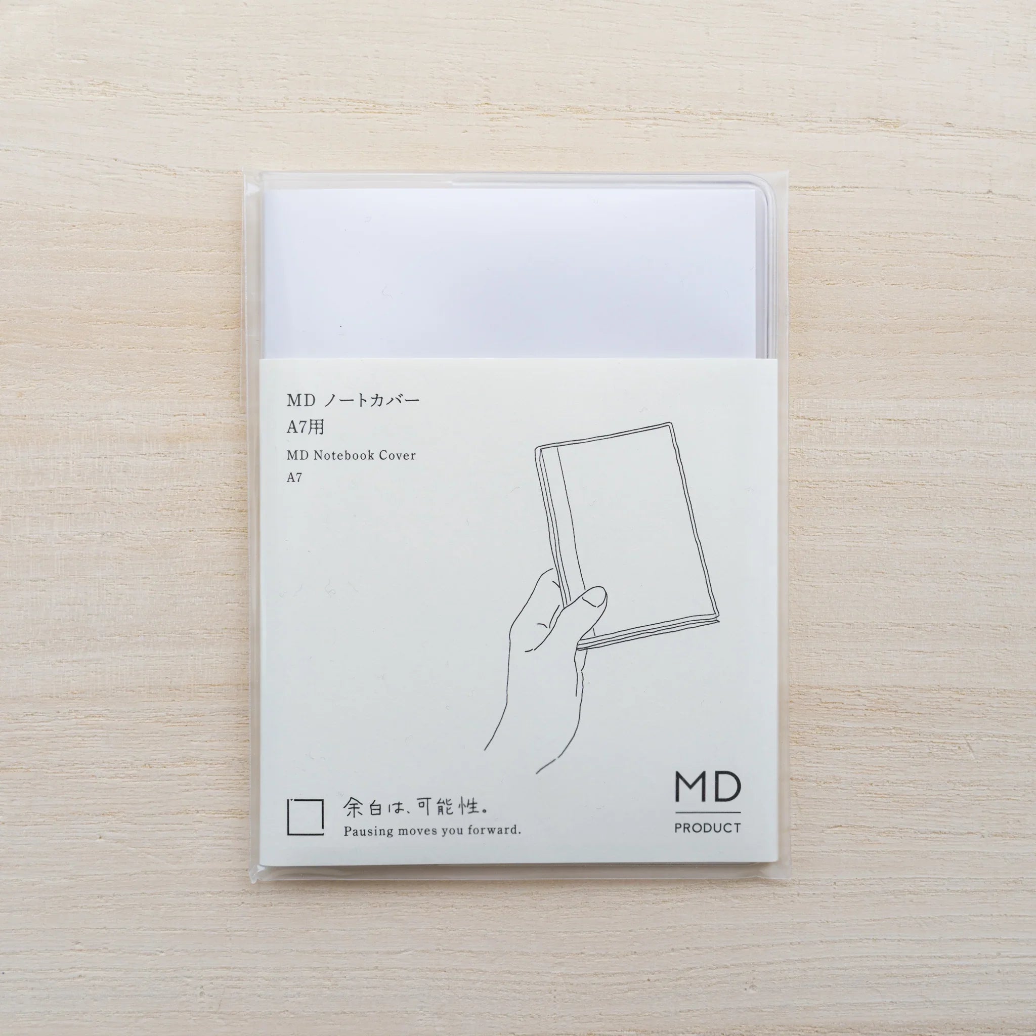 MD Notebook Cover A7 package with black line illustration of a hand holding a notebook and MD Product logo