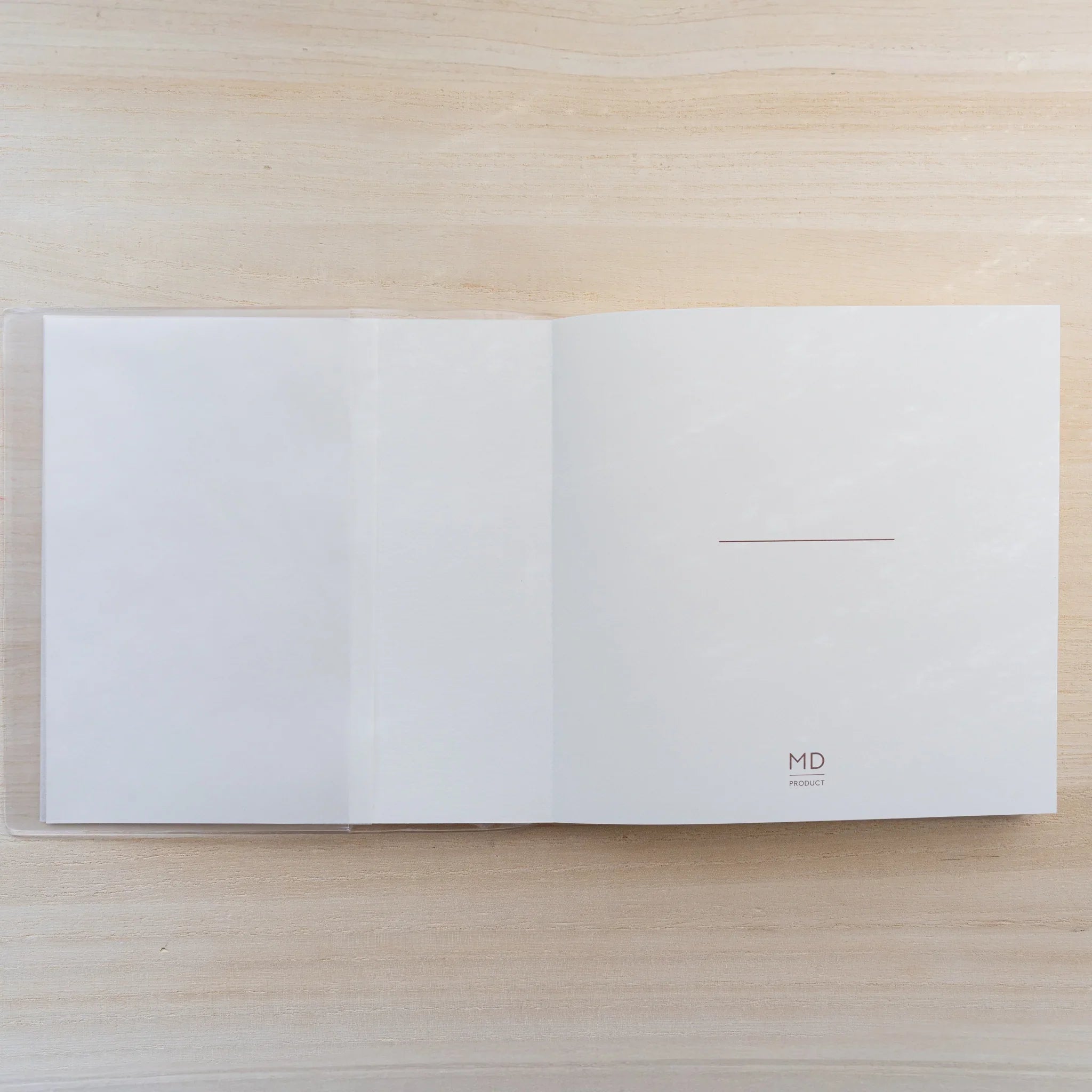 Midori MD Notebook Cover A5 Square opened flat in clear PVC showing a blank white square spread
