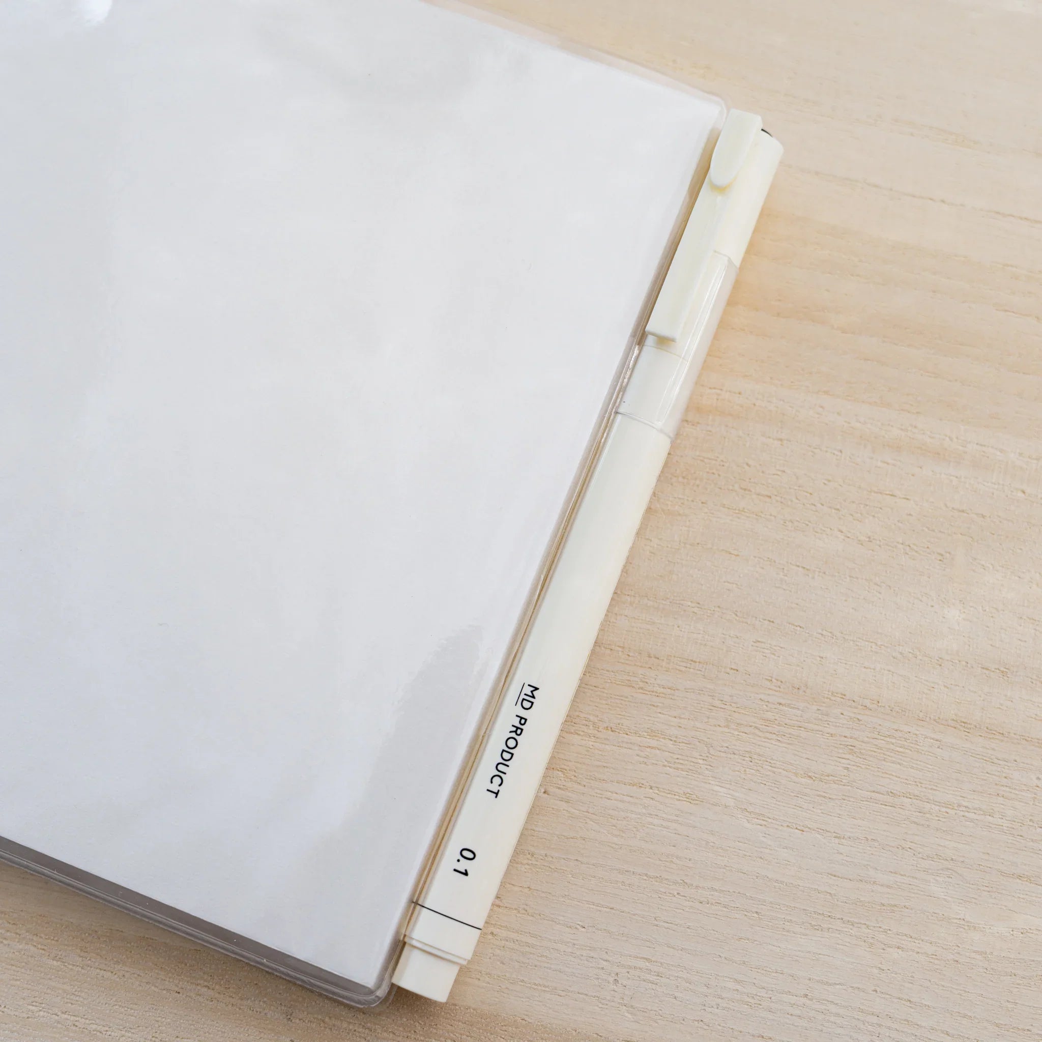 Side view of a square MD notebook inside clear PVC Midori MD Notebook Cover A5 Square
