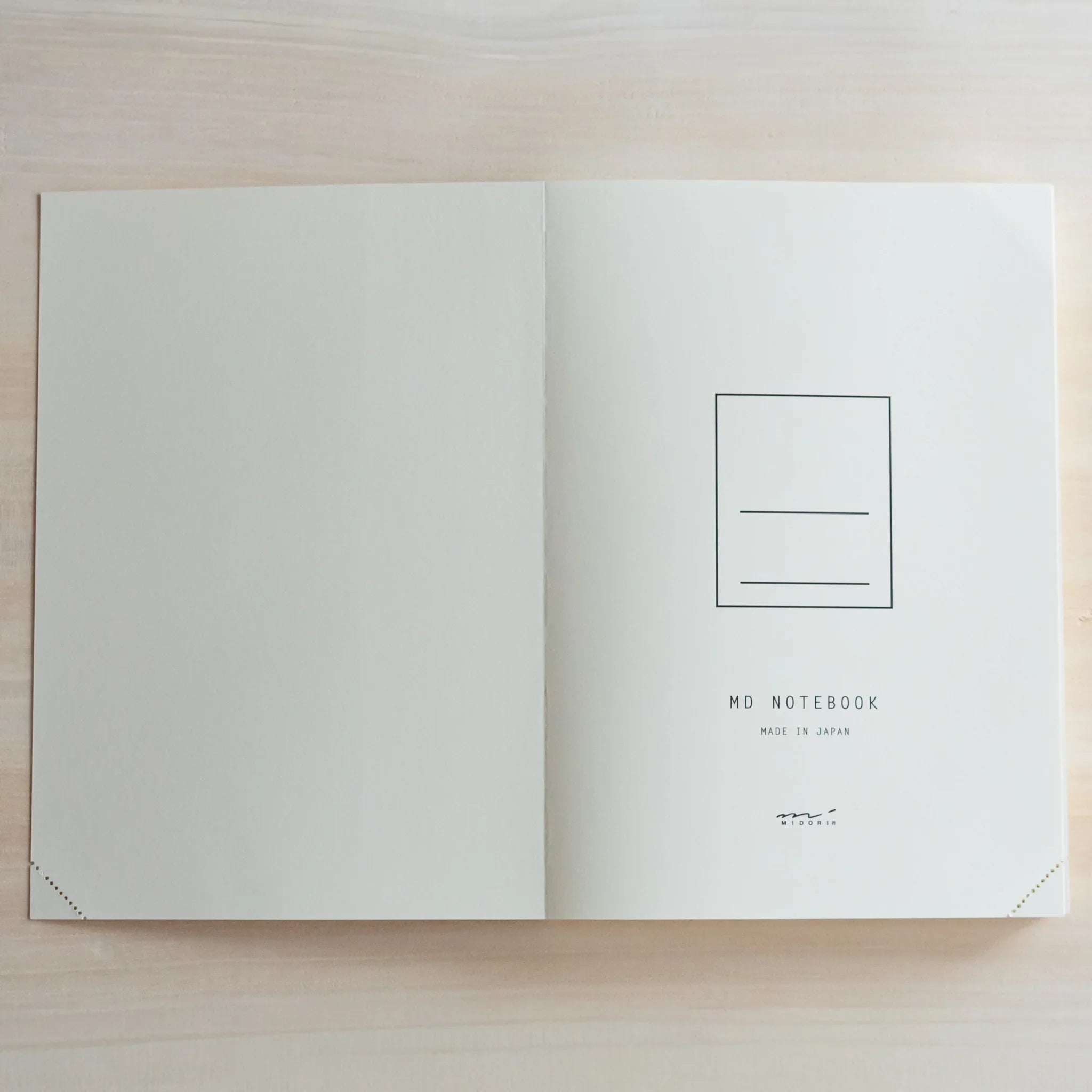 Top view of open Midori Japanese journal showing inside cover and MD Notebook title page with square outline.
