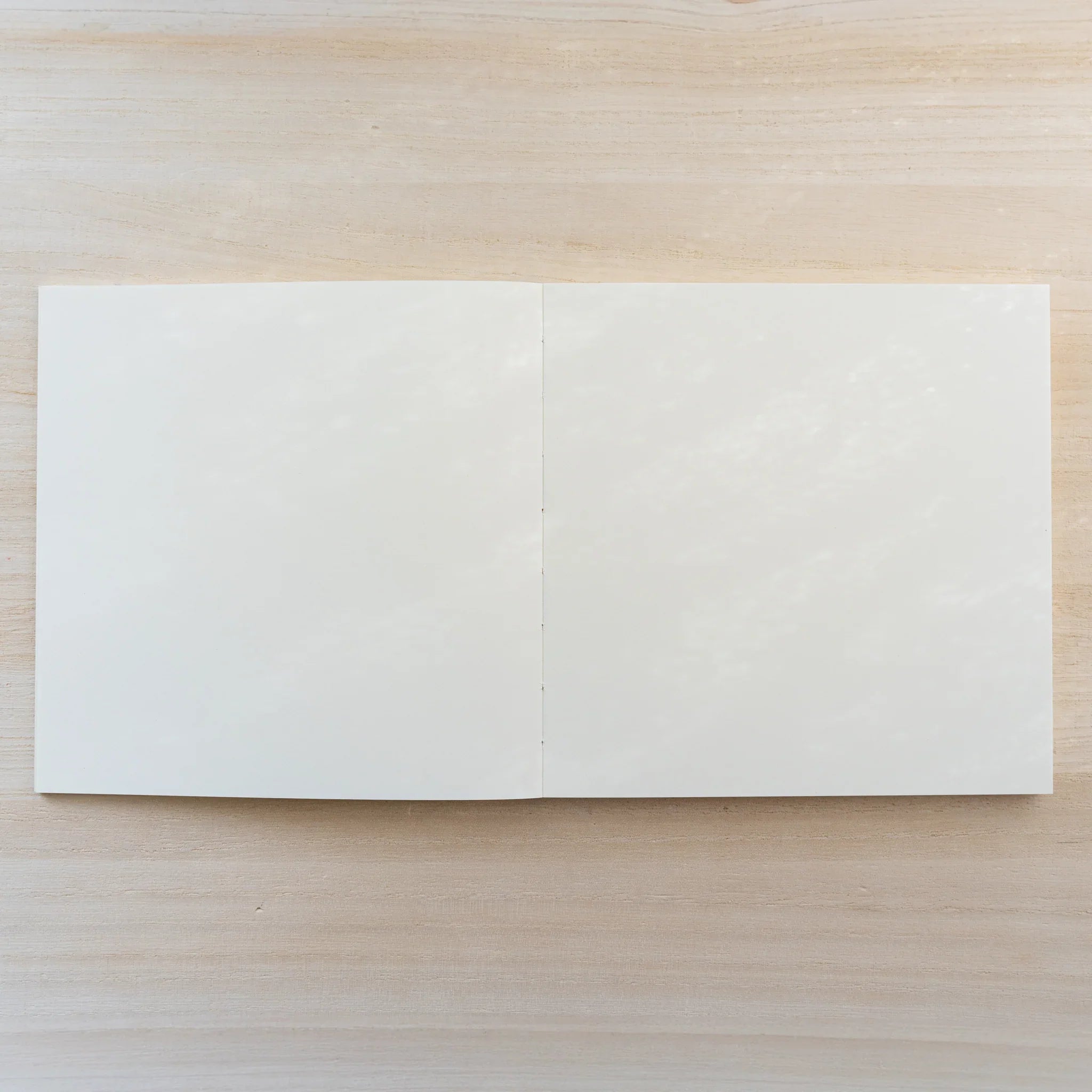 Square cream MD Notebook Thick Paper A5 Square, closed front view on a wood surface