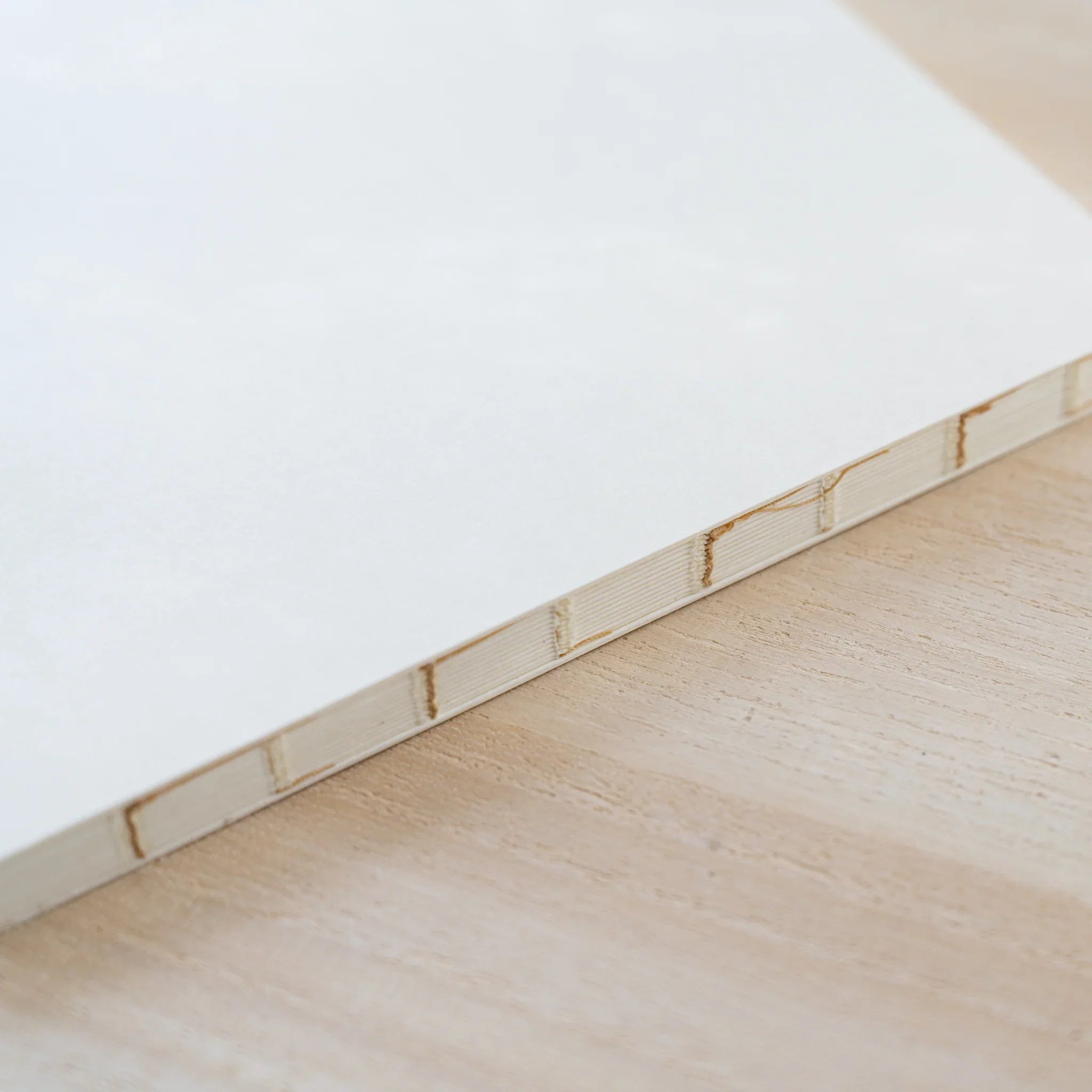 Close-up of the MD Notebook Thick Paper A5 Square spine showing thread binding and page edges