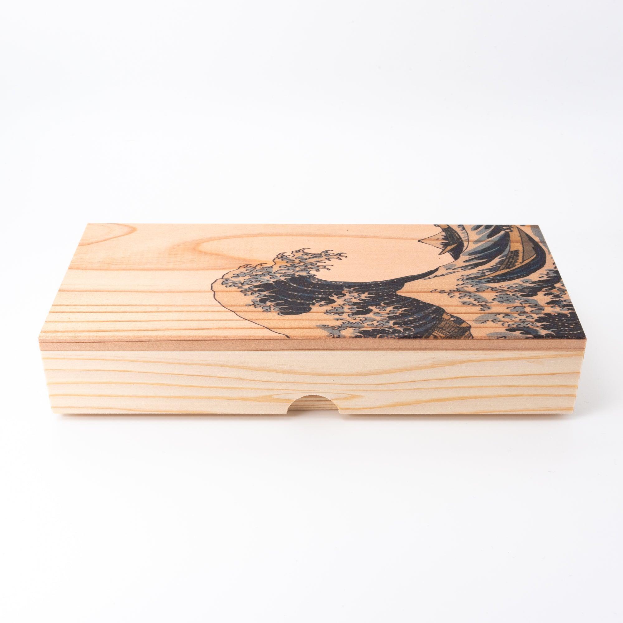 A side view of a Japanese wooden pen case with "The Great Wave off Kanagawa" engraving, emphasizing its traditional craftsmanship and elegance.  