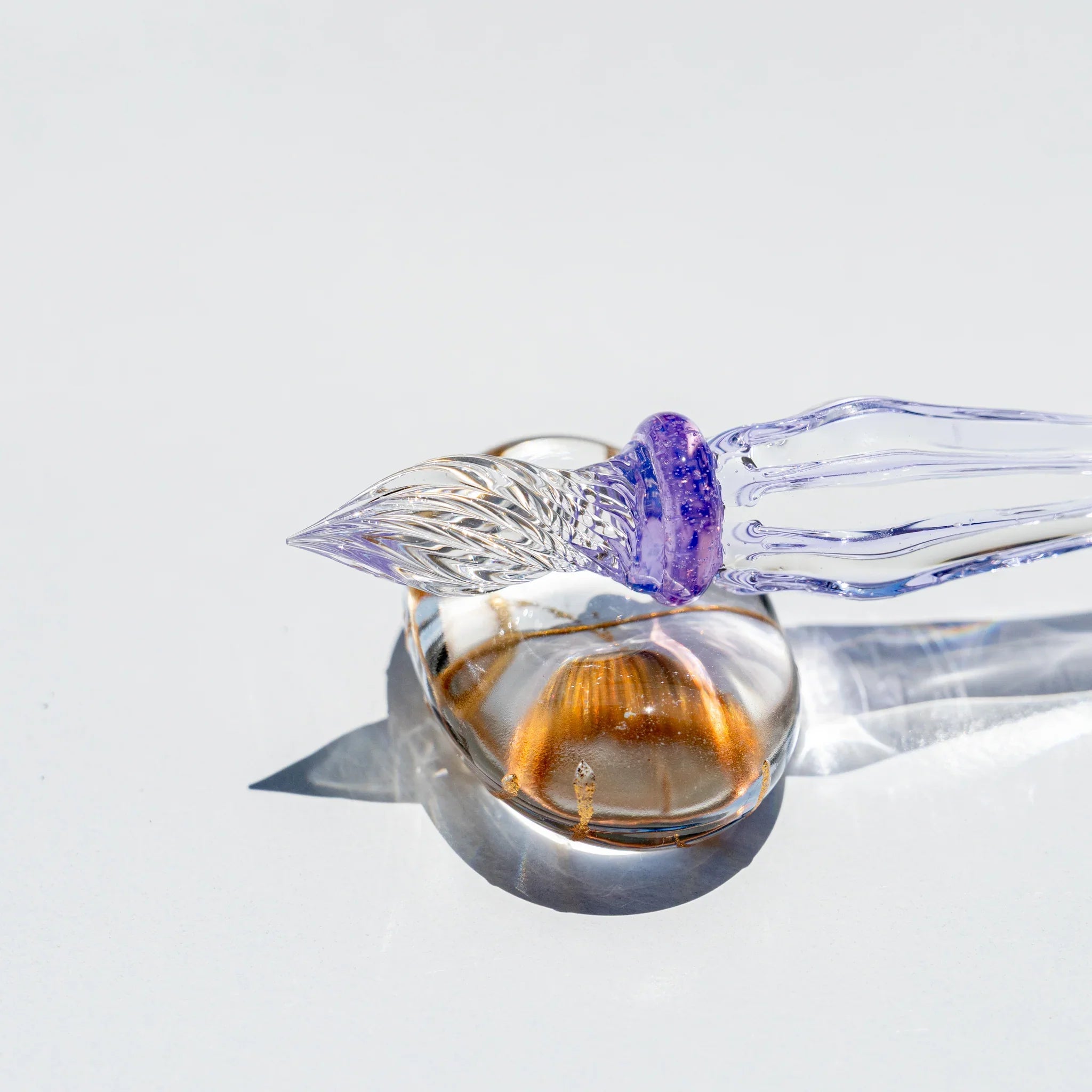 Side view of the Moonlit Cloud glass dip pen with clear grooved nib, purple collar and ribbed lavender glass barrel