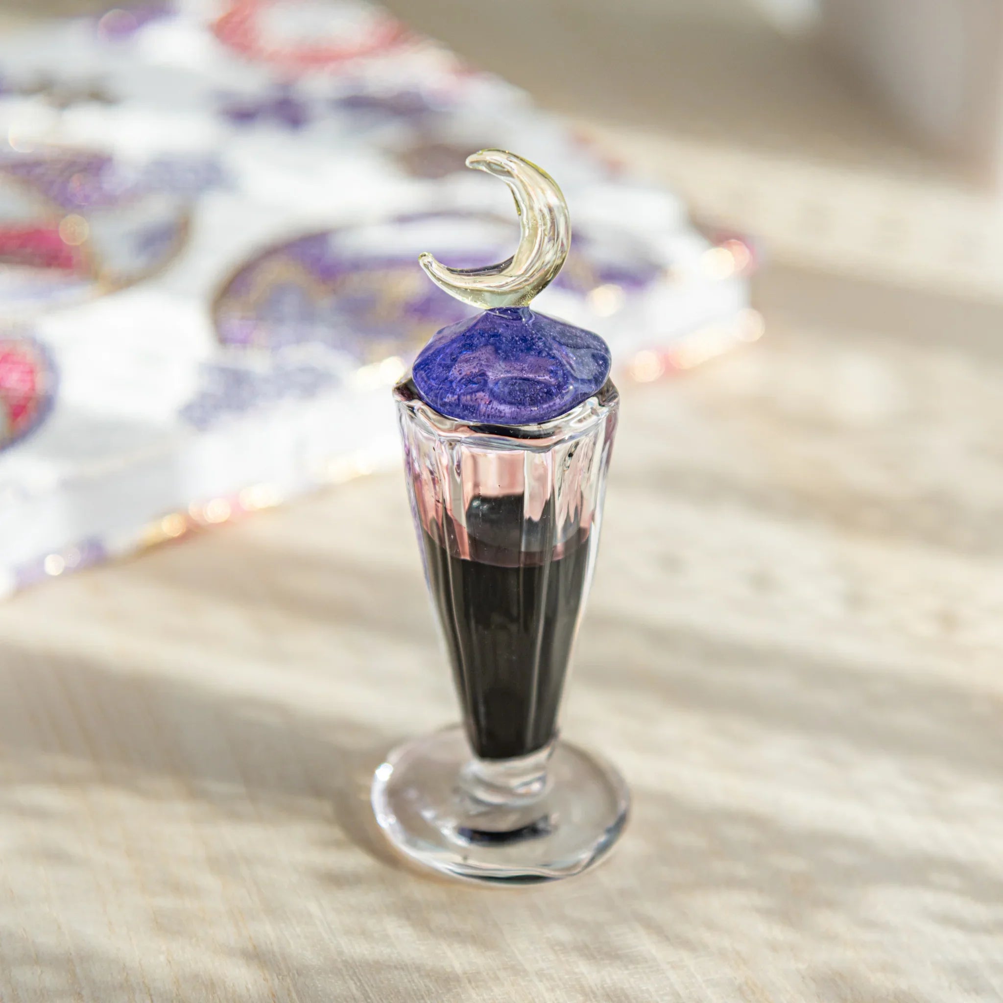 Japanese glass ink well filled with black ink, topped with a crescent moon lid, bringing elegance and function to your writing desk.