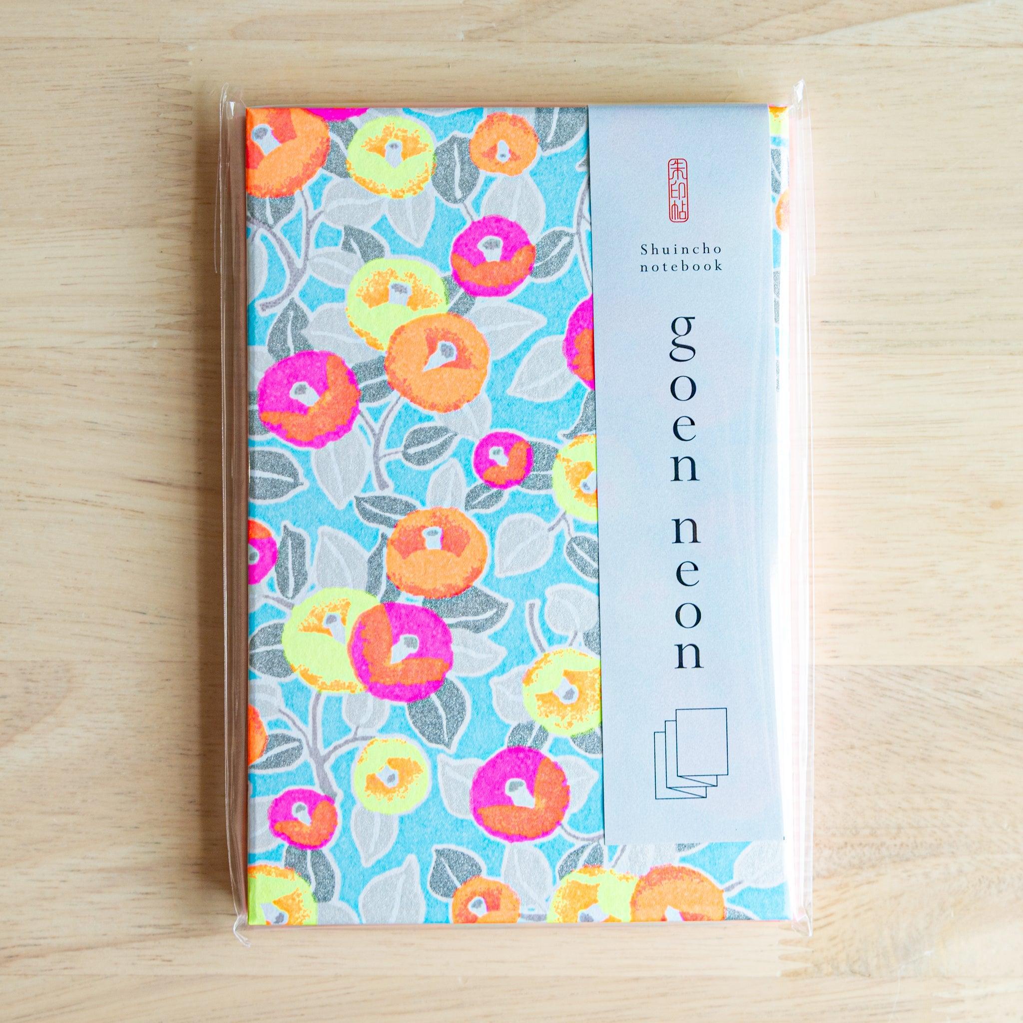 Goshuincho stamp book with neon camellia design in clear wrap, perfect Japanese stationery for shrine stamp collecting.