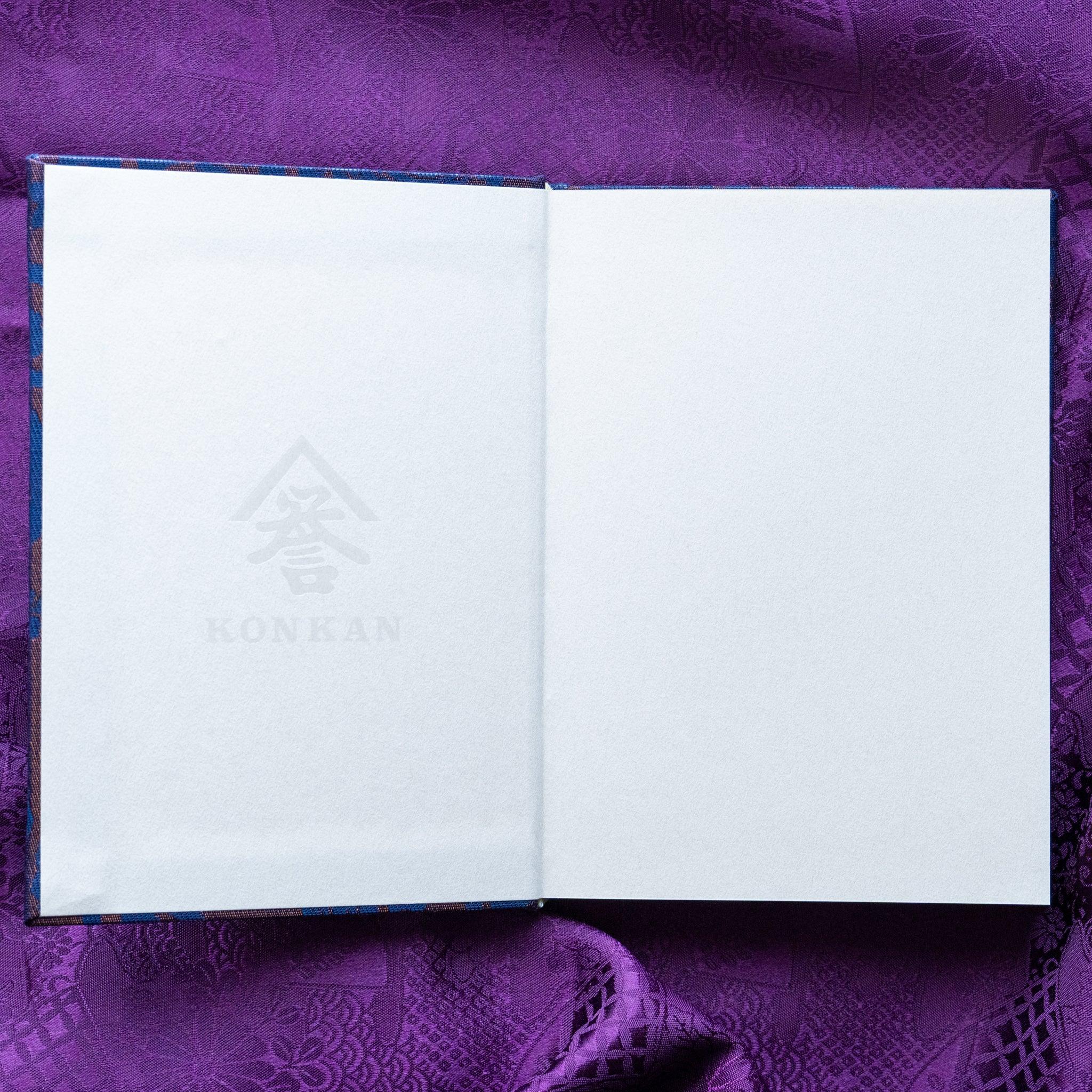 Oni Kiri Nishijin silk Homeicho notebook opened to inner cover showing large KONKAN watermark on cream endpaper on purple