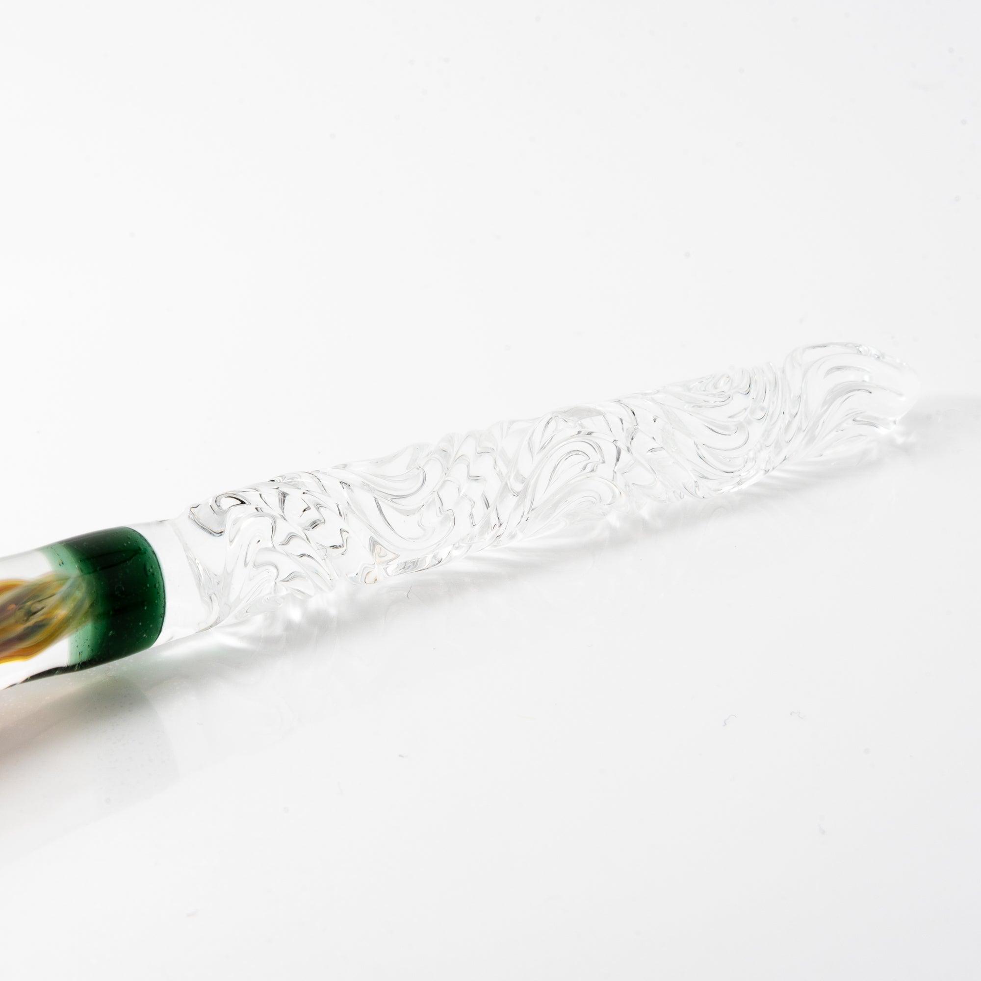 A delicate glass pen with an intricate orange rose motif, resting on a clear pen holder.