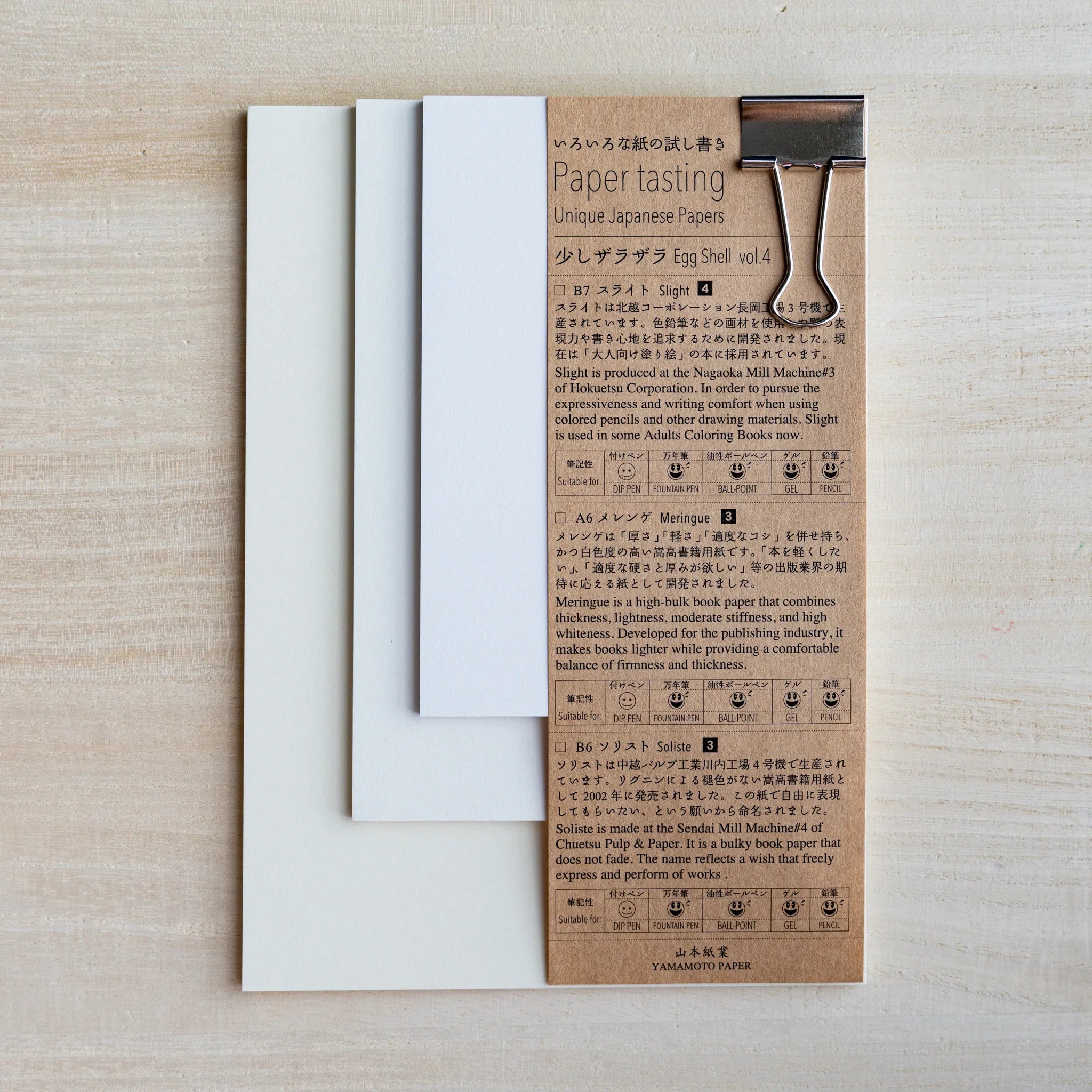 Paper tasting Egg Shell vol.4 set, cream sample sheets fanned beside kraft cover with binder clip on wood