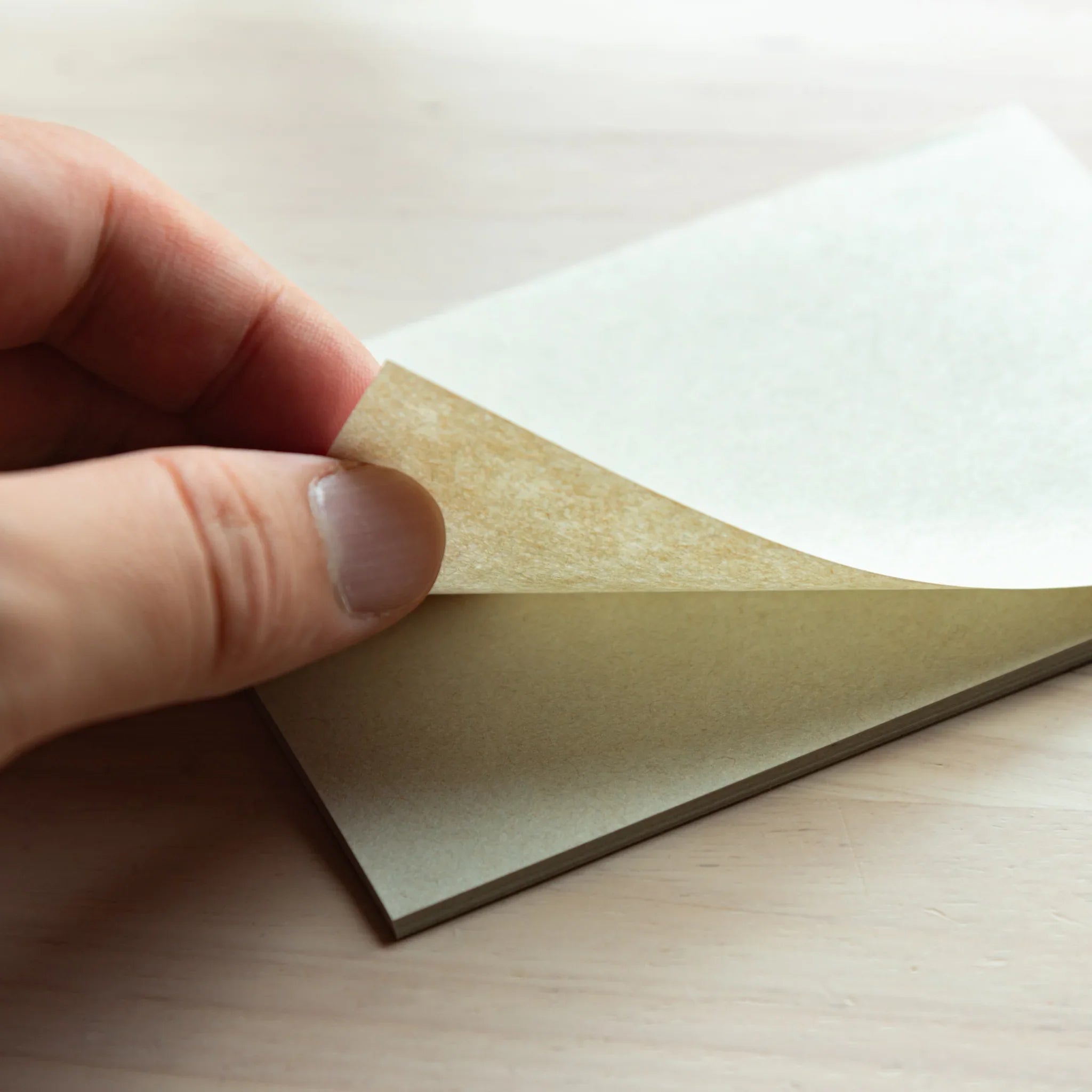 Page being lifted from Paper Tasting Writing Pad Set Gray vol.4, Japanese Note Book sampler showcasing thin flexible sheets.