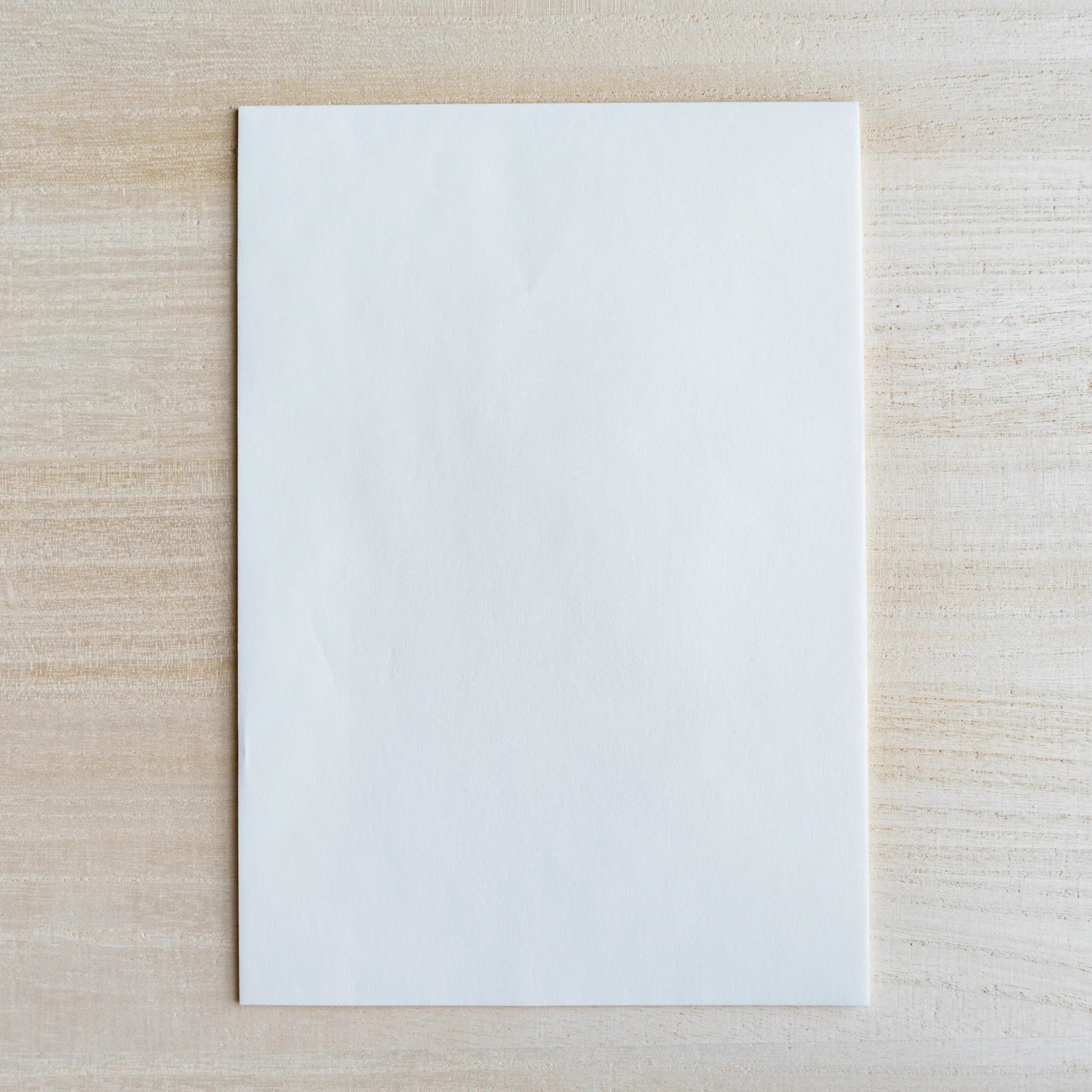 Single thin translucent onionskin sheet on light wood surface