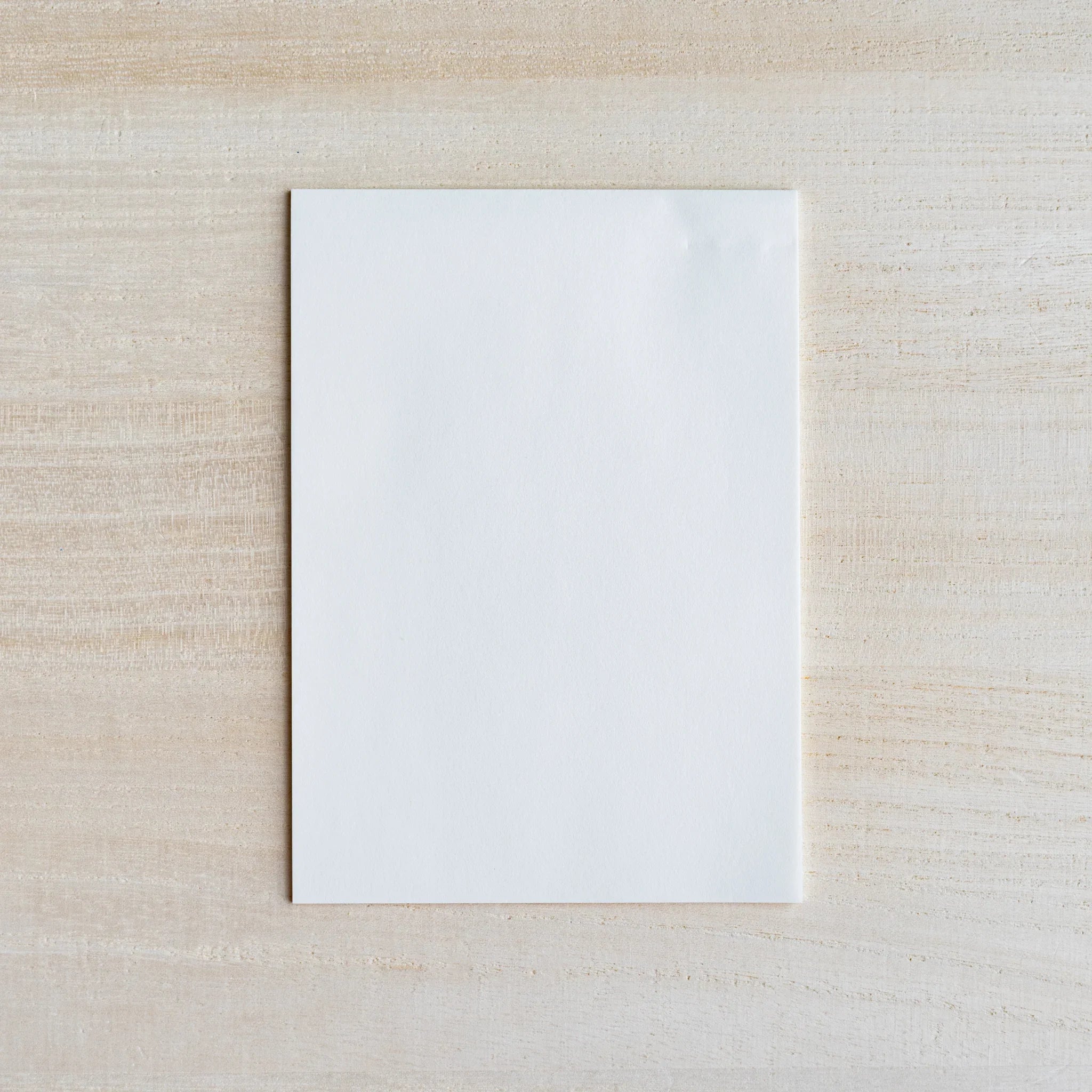 Single thin translucent white onionskin sheet on light wood surface