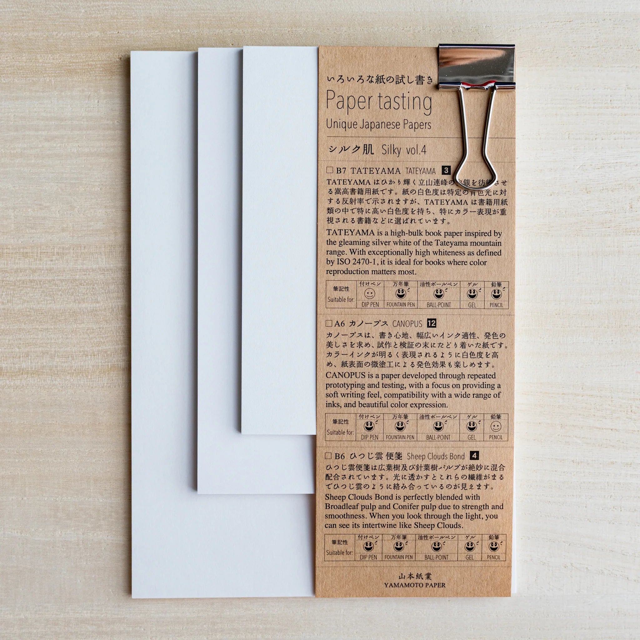 Paper tasting Silky vol.4 set, white sample sheets fanned beside kraft cover with binder clip on wood