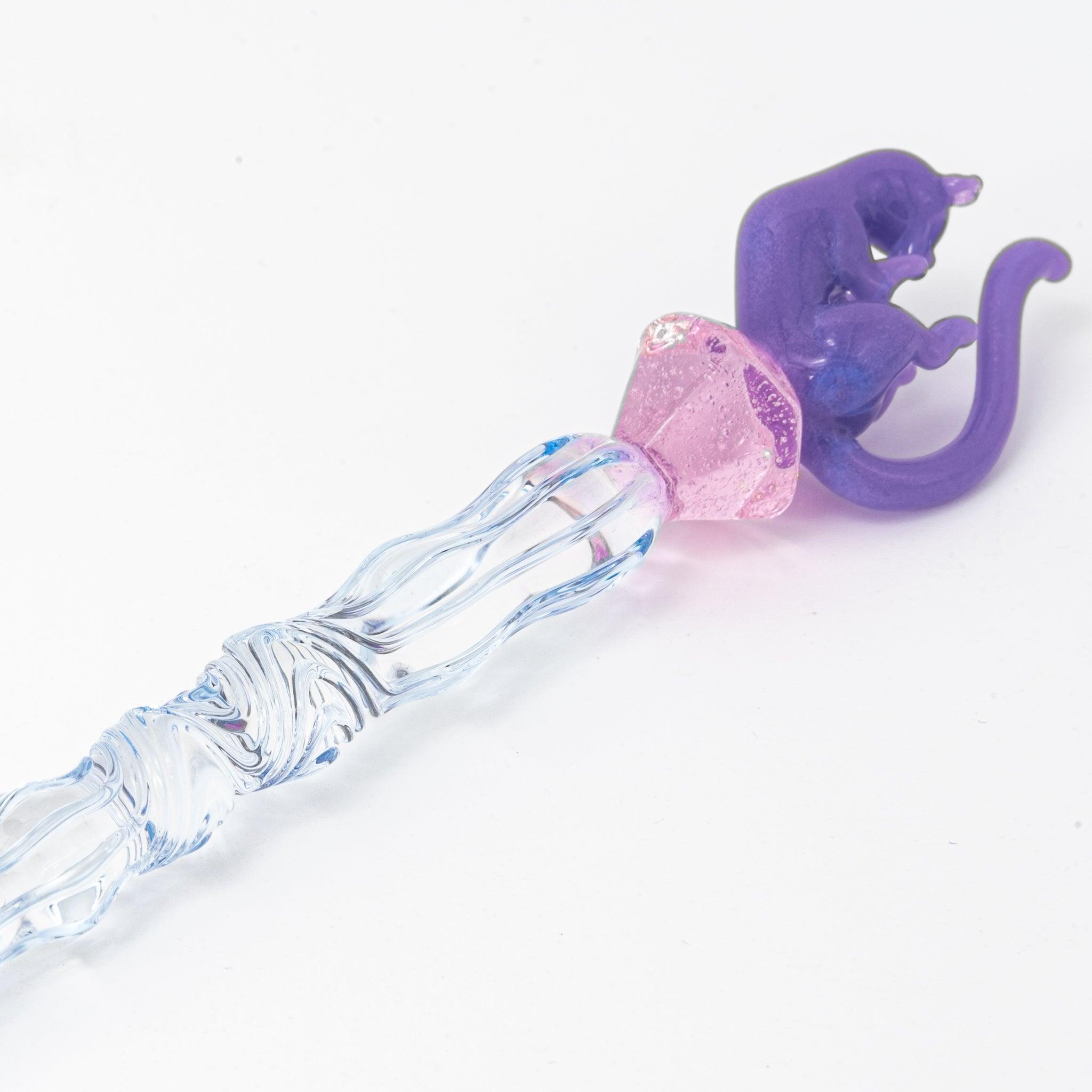 Glass pen with a blue shaft, purple cat topper, and pink charm. Includes matching purple pen rest. Perfect for Japanese stationery lovers.