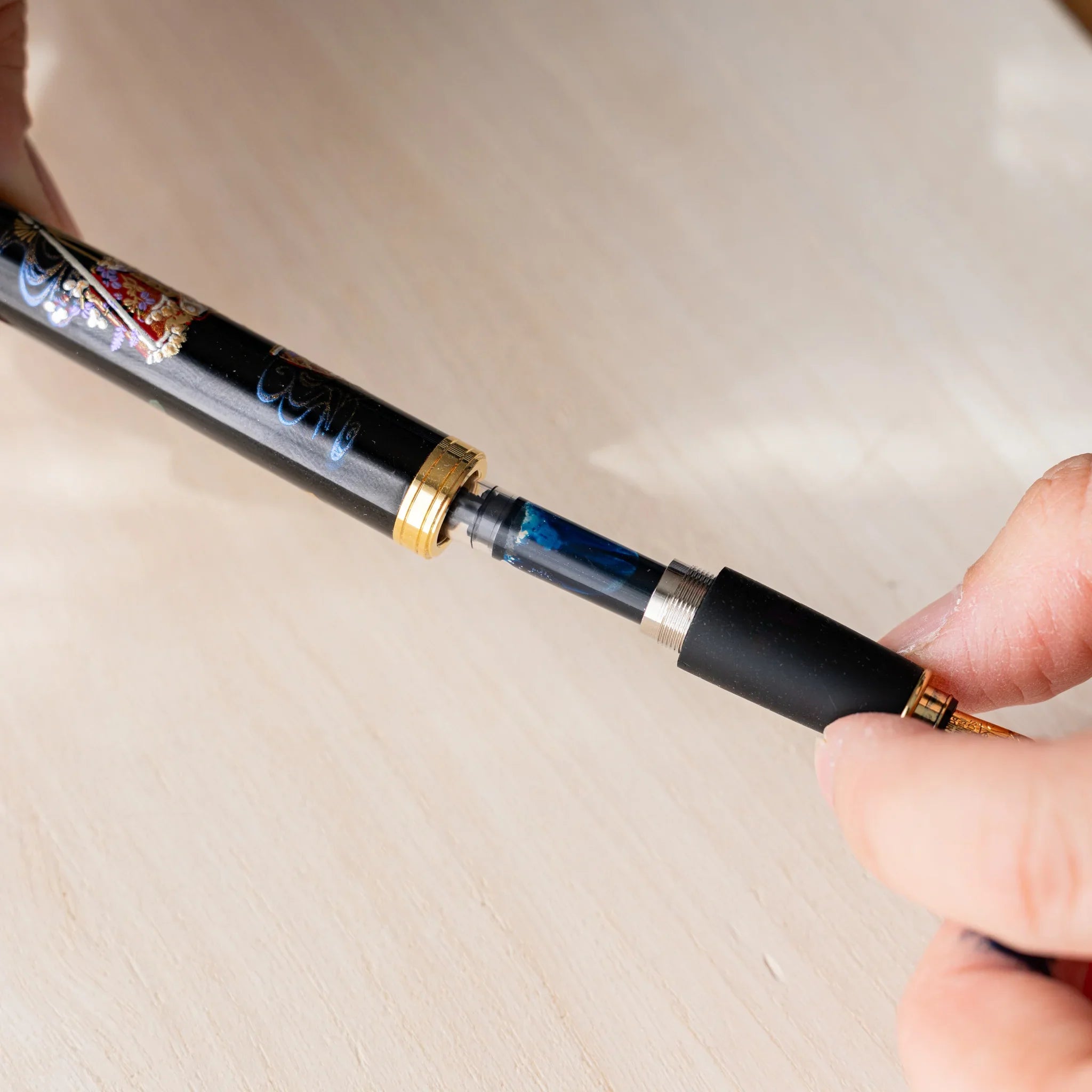 Hand inserting a Pelikan piston converter into a Yamanaka Japanese fountain pen body.