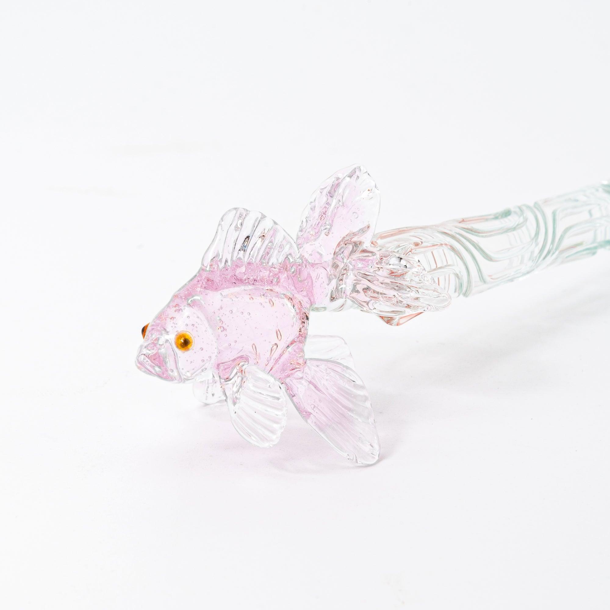 The pink goldfish glass pen photographed on a white background, displaying the clear glass body and the intricately sculpted goldfish in pink glass at the top.