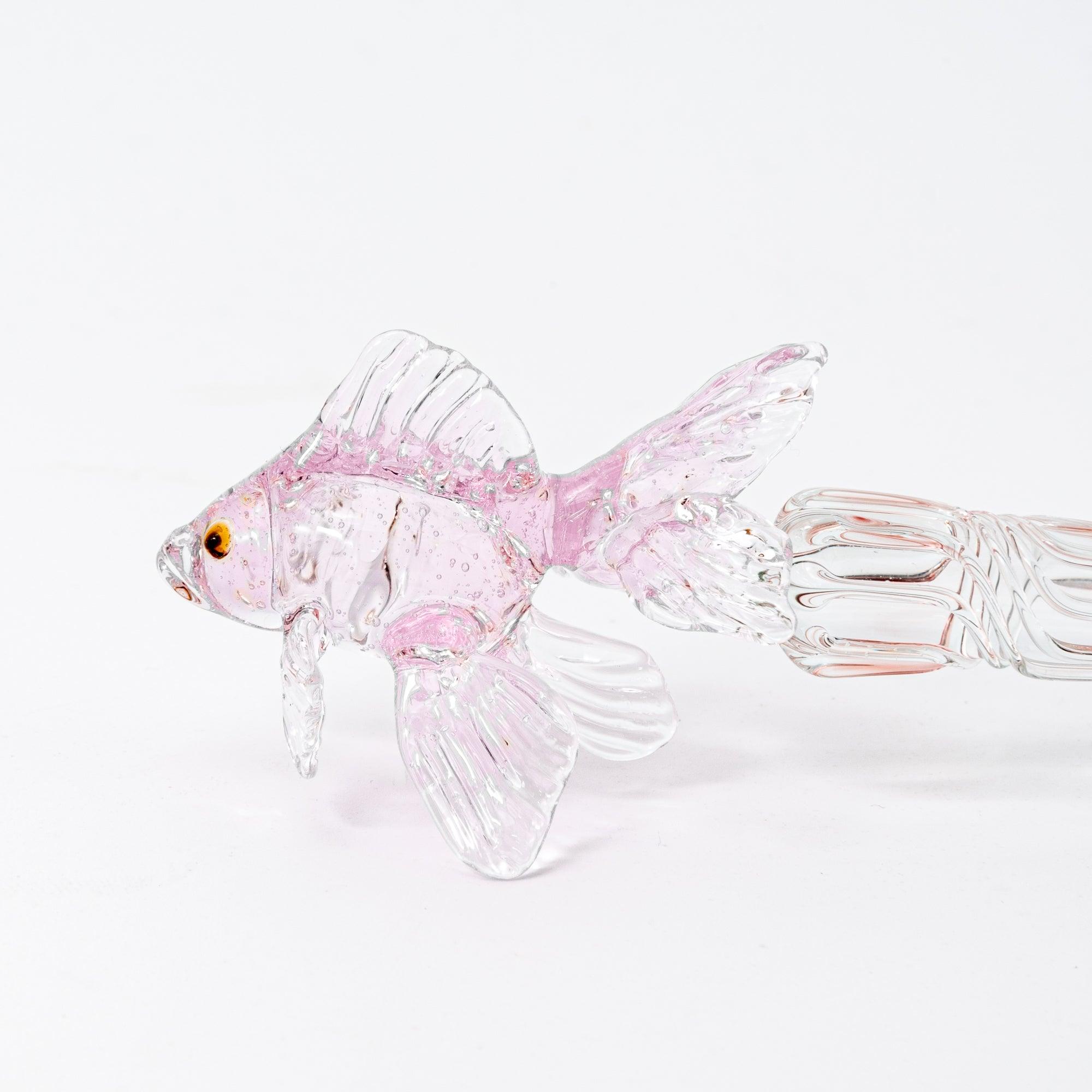 The pink goldfish glass pen photographed on a white background, displaying the clear glass body and the intricately sculpted goldfish in pink glass at the top.