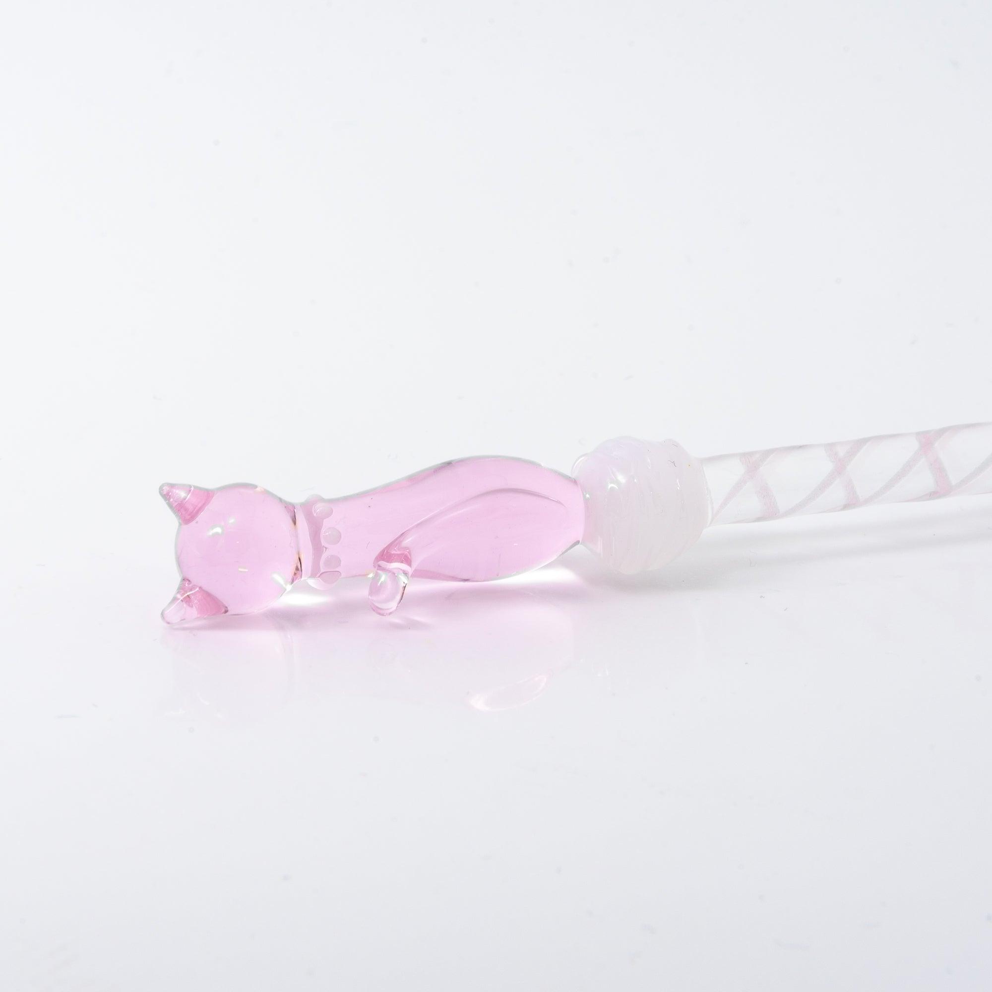 A delicate pink glass dip pen featuring a cat design at the top and a twisted, clear handle, creating a whimsical and elegant look.