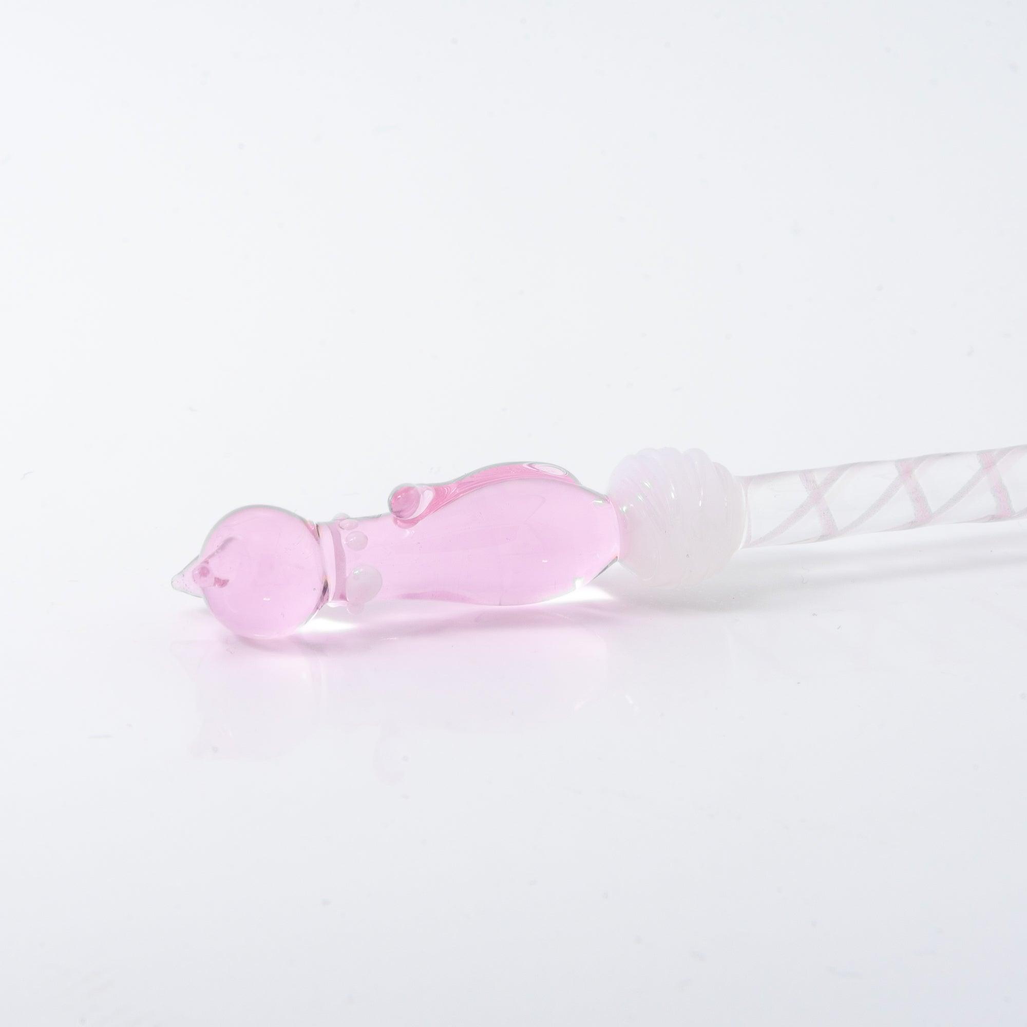 A delicate pink glass dip pen featuring a cat design at the top and a twisted, clear handle, creating a whimsical and elegant look.