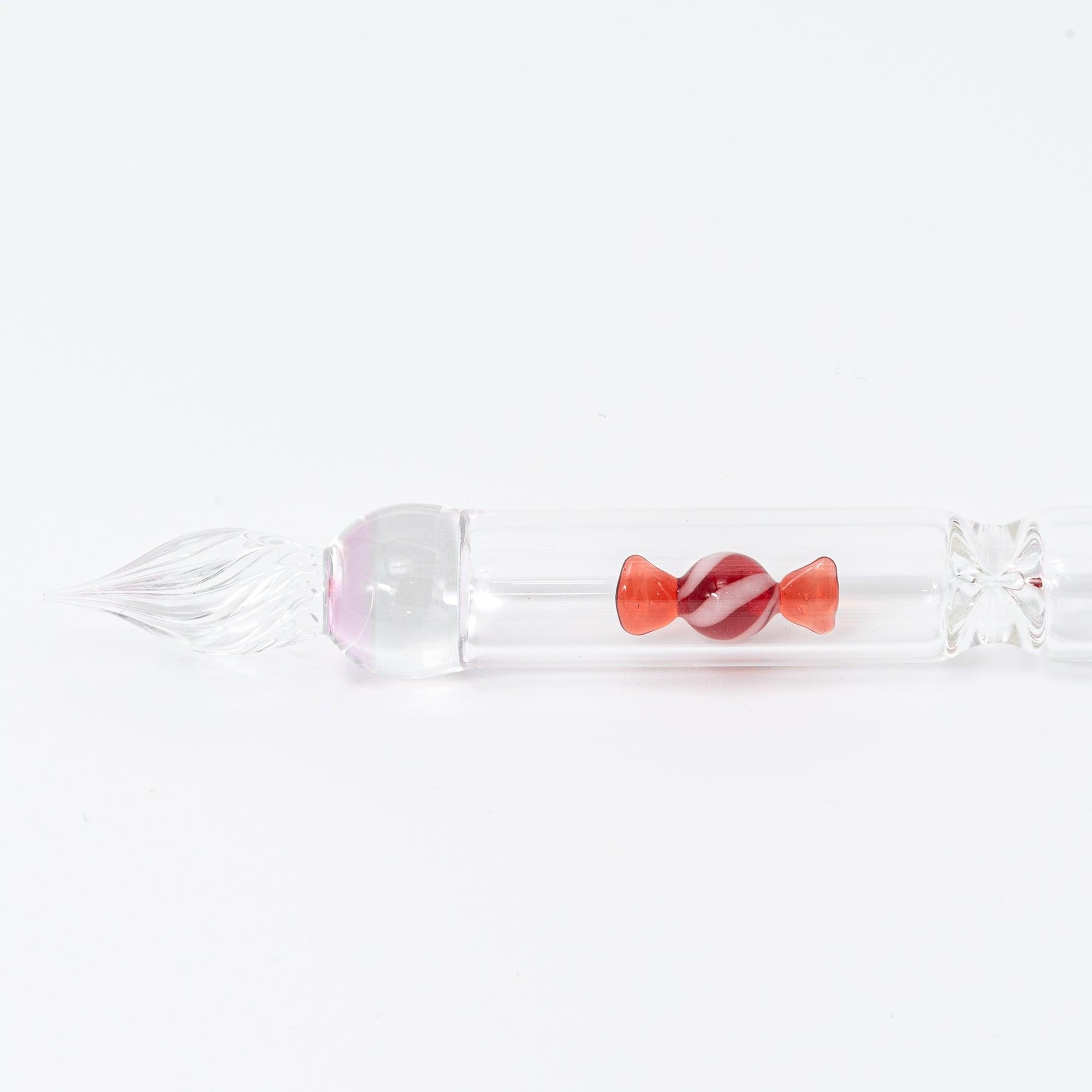 A red candy motif is captured inside this elegant glass pen, offering a whimsical yet sophisticated design for any stationery enthusiast.