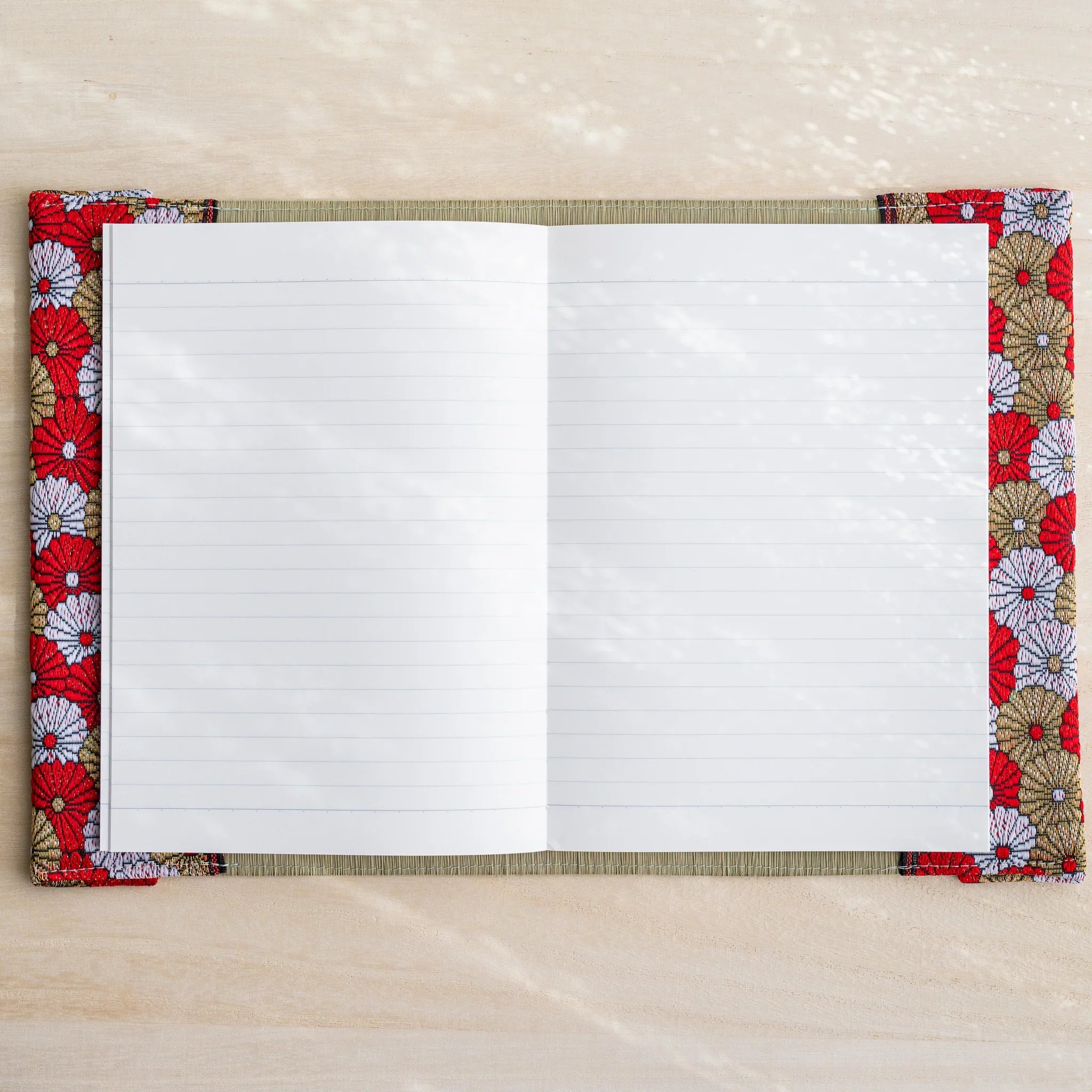 Tatami book cover open flat with white lined notebook pages, red white and gold Japanese chrysanthemum fabric edges