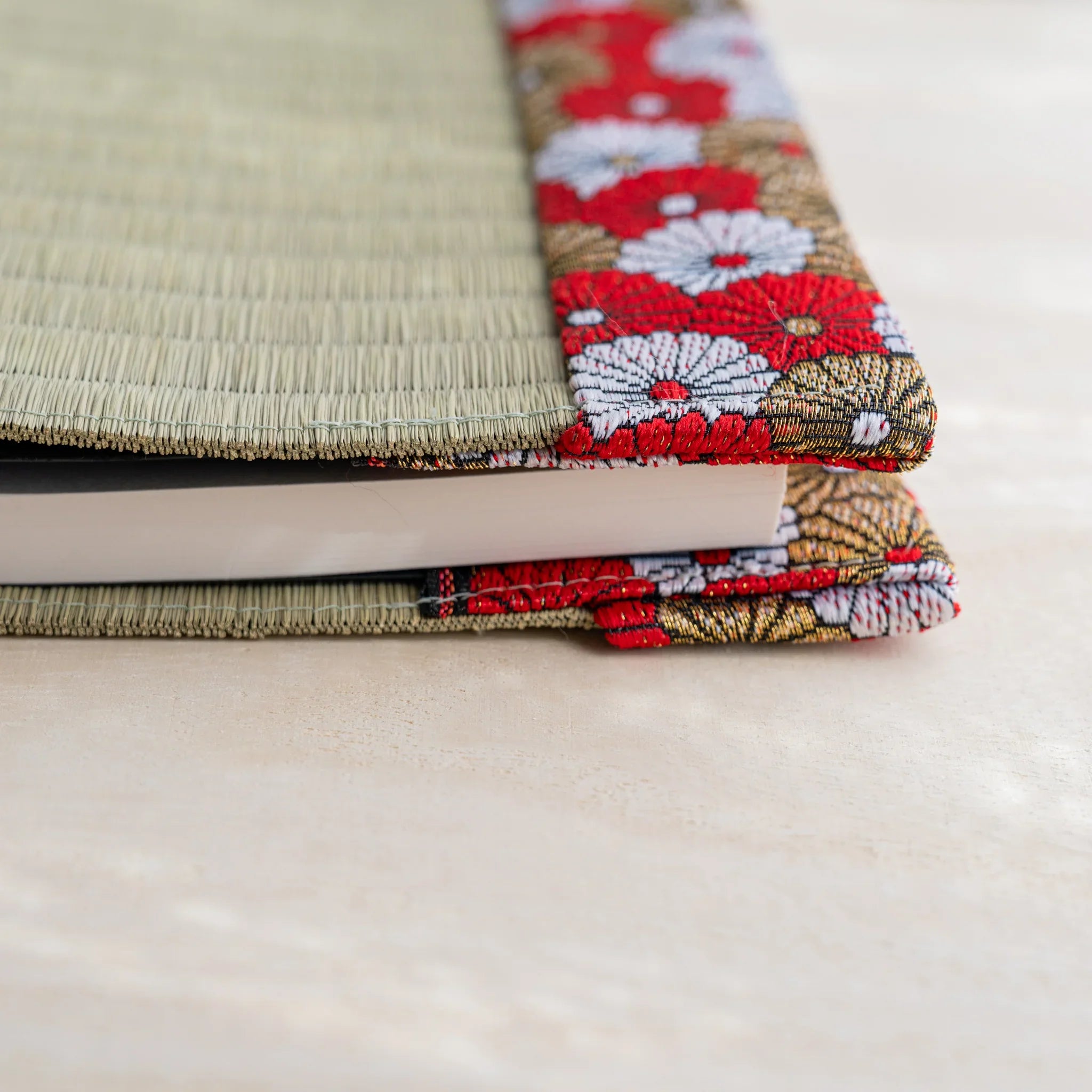 Side view of chrysanthemum tatami book cover with notebook inserted, showing thickness and folded patterned flap