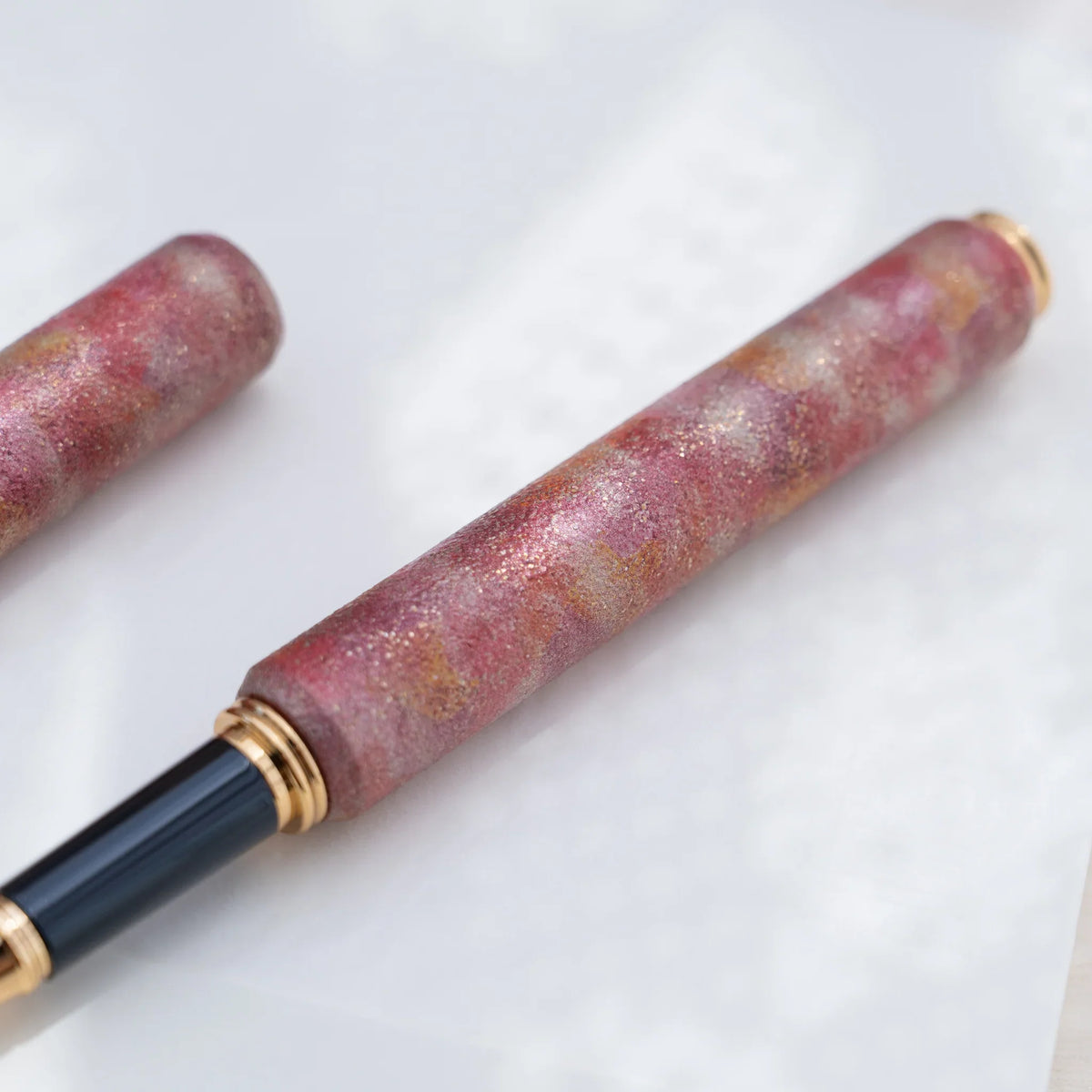 Detail of the layered color urushi and tin powder finish on the red pen