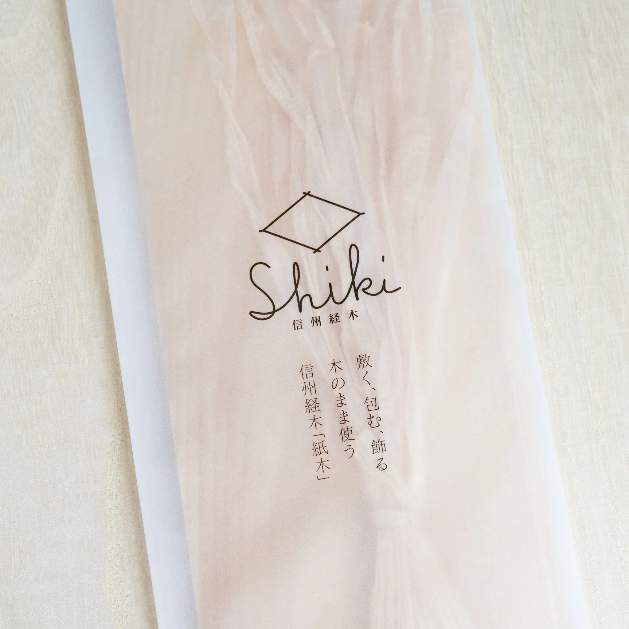 Close-up of Shiki package with Japanese text and diamond logo, Hinoki strings visible through translucent sleeve