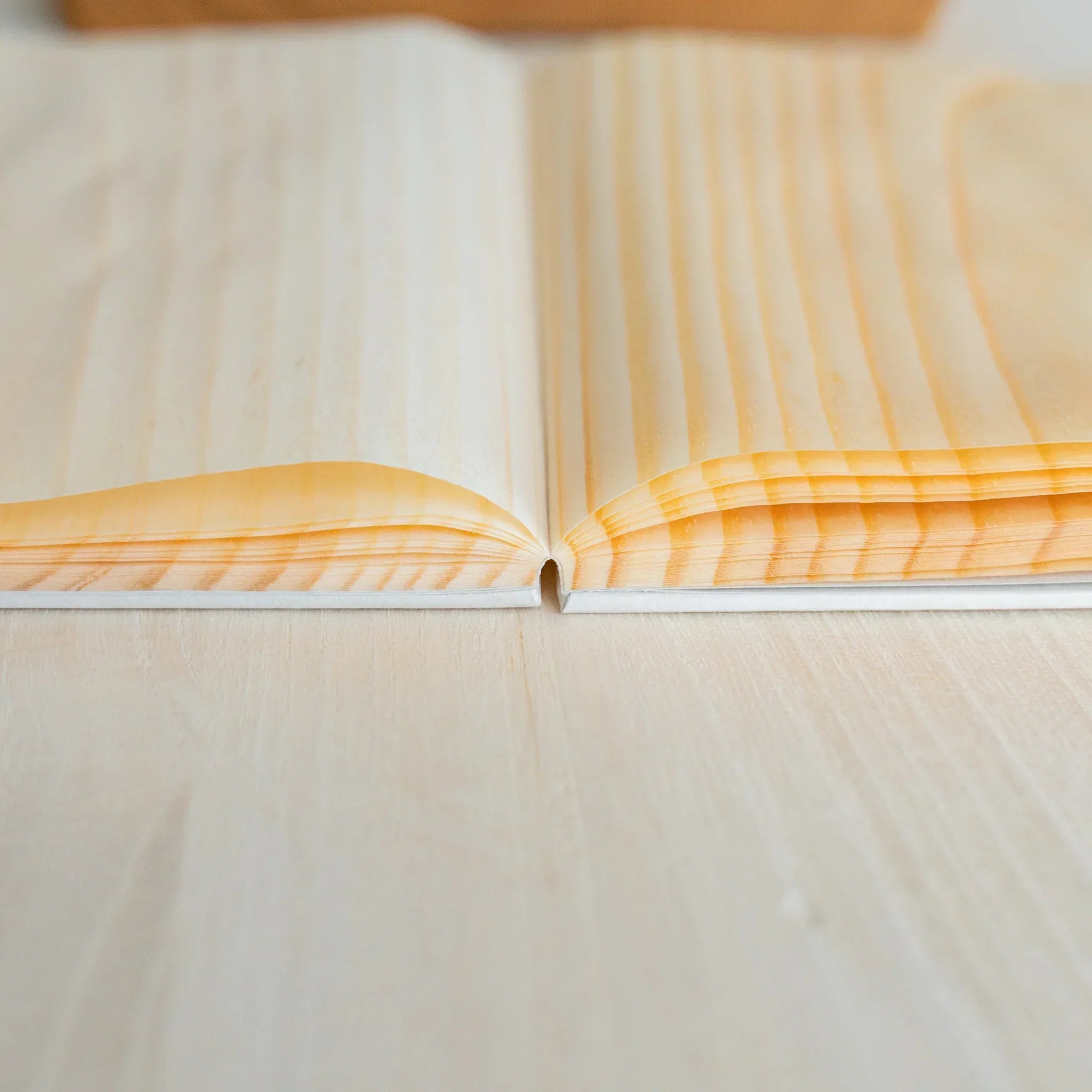 Red Pine B6 journal with wooden pages, angled side profile of binding and wooden page construction showing natural wood