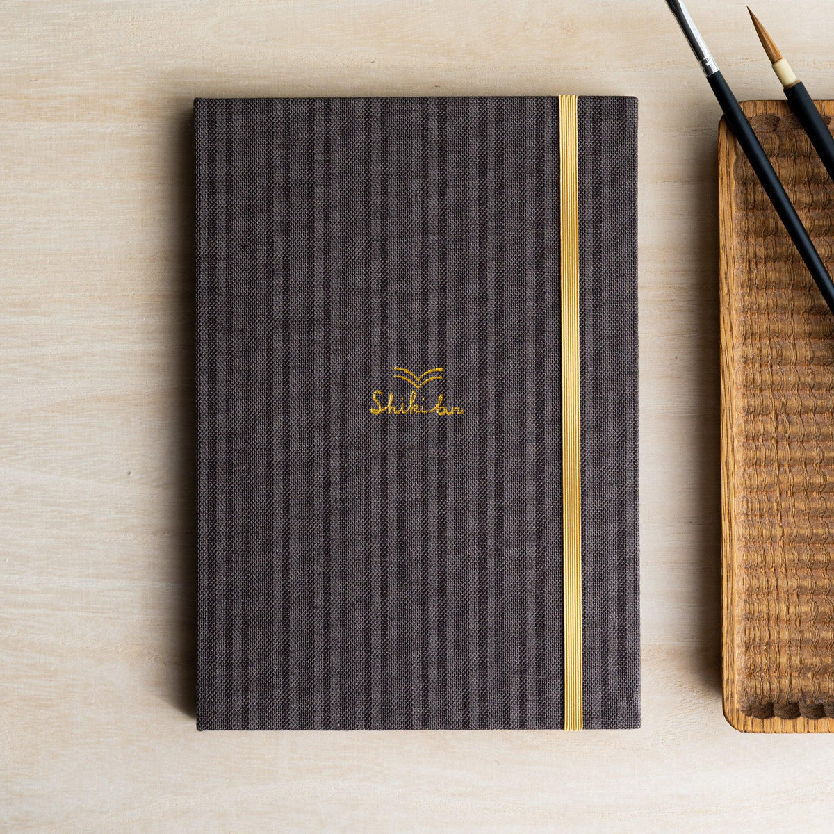 Red Pine Wooden Page Sketchbook Brown, dark brown cloth cover with gold Shiki bun logo and yellow elastic band