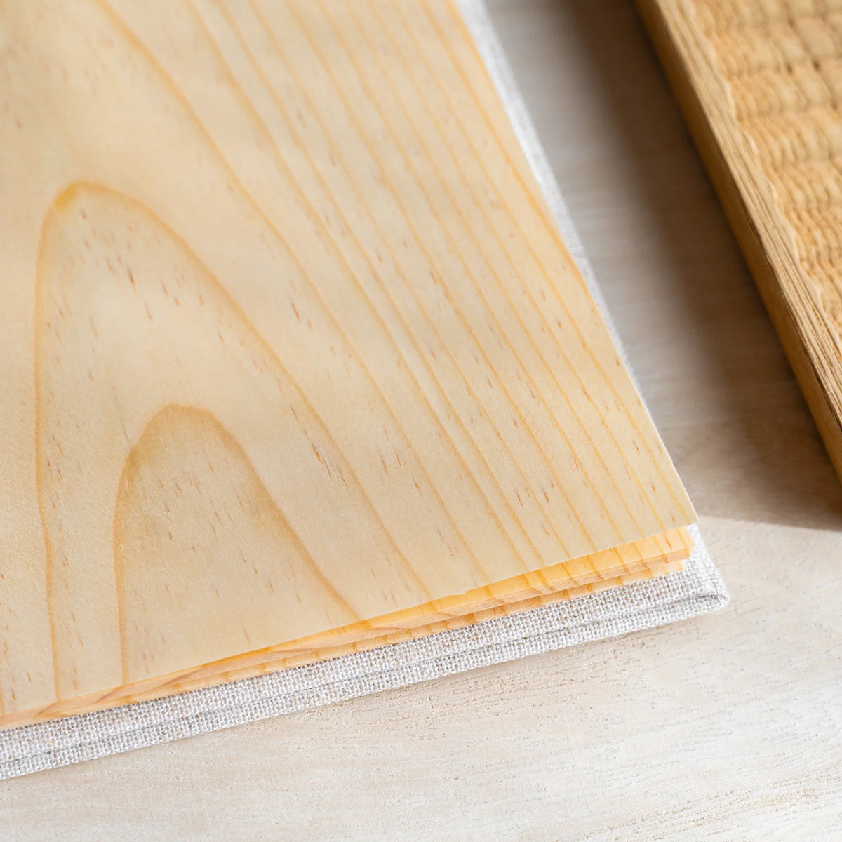 Close-up of stacked wood sheet pages with grain pattern, fanned edges showing sheet thickness