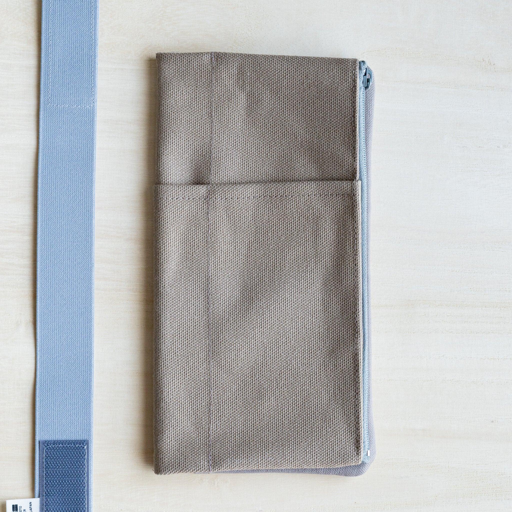 RO-BIKI clay beige canvas cover beside its pale blue elastic band with a hook and loop adjustment tab